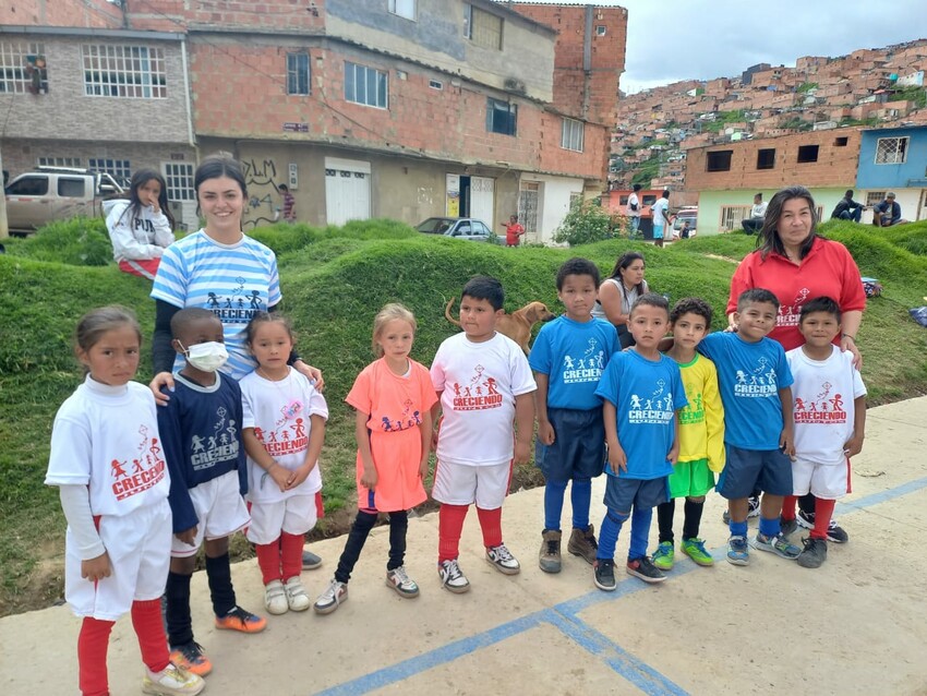 Two women stand with a group of kids