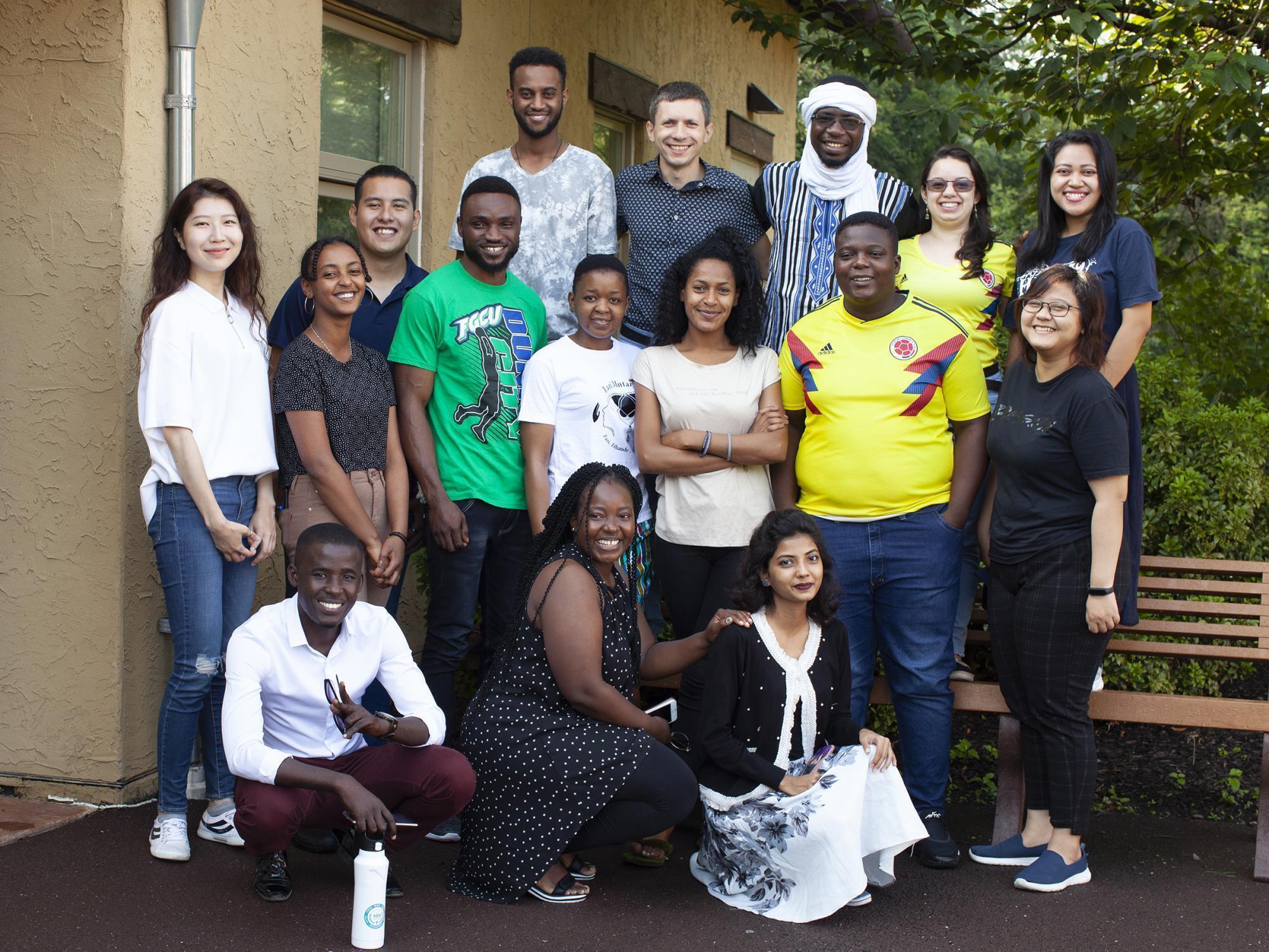 A group of 16 young adults of different nationalities pose for a photo