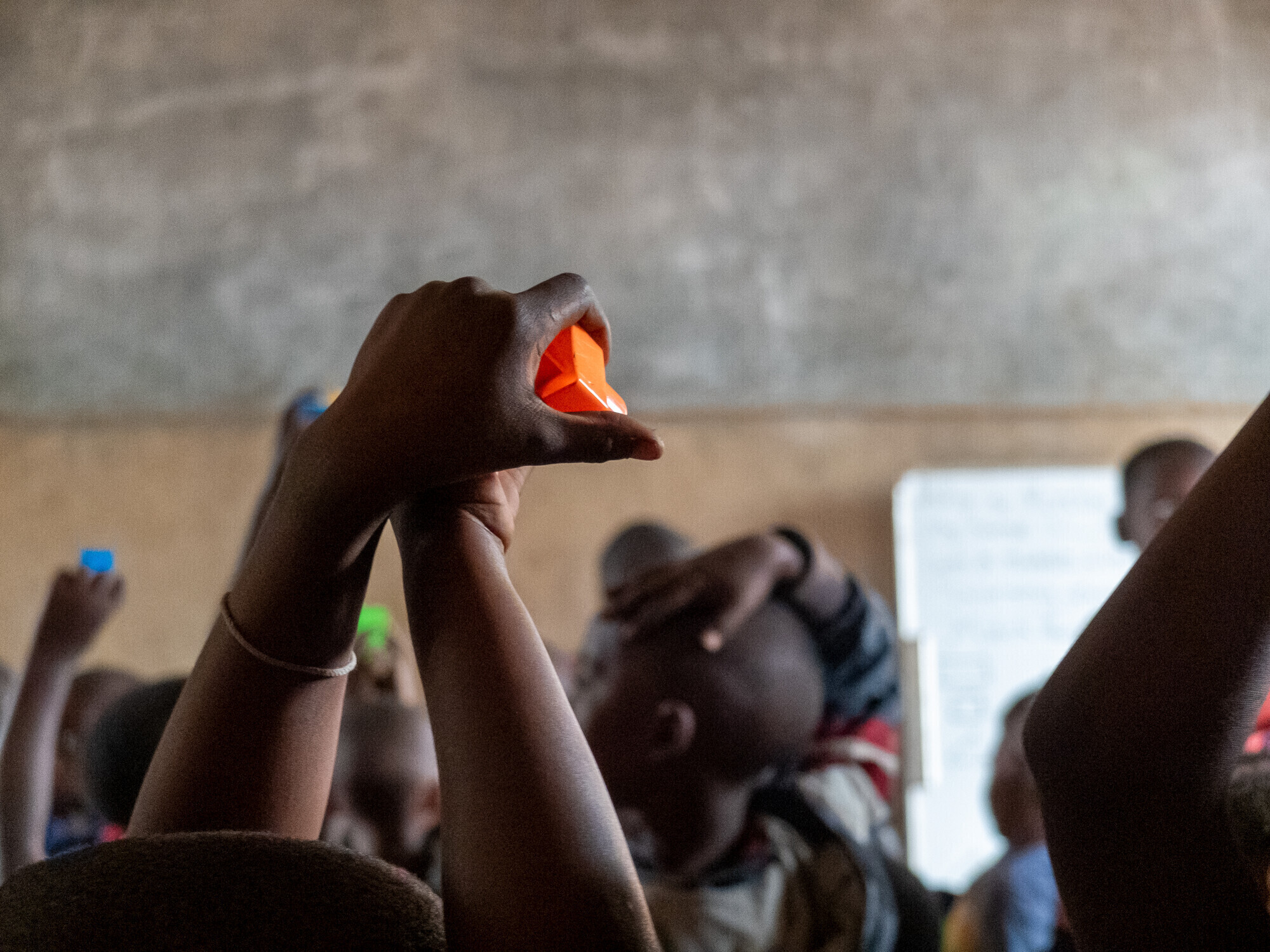 children in classroom holding plastic blocks