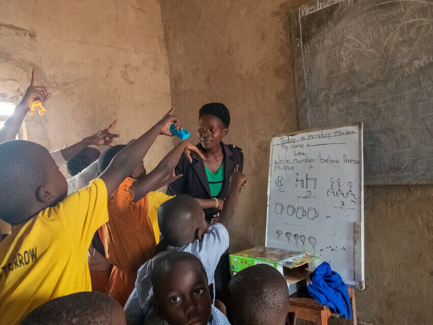 child raise hands for turn at whiteboard