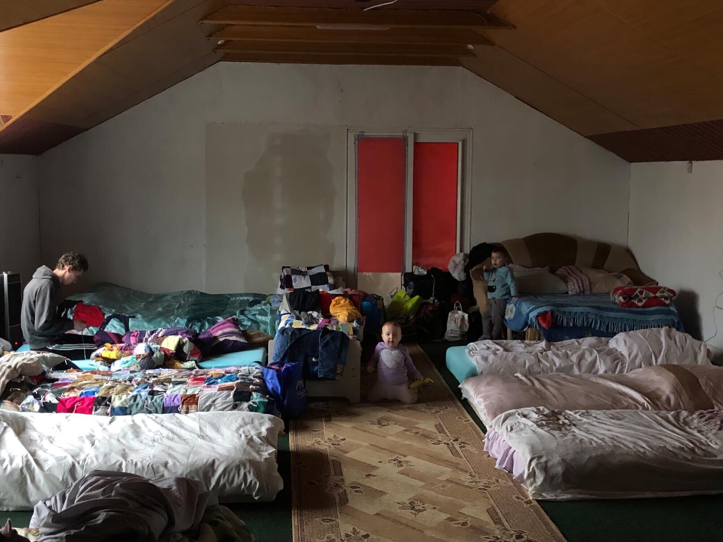 Children rest on top of mattresses and blankets