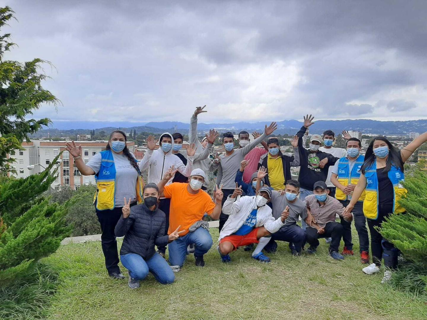 A large group of people wearing face mask pose in two rows for the camera