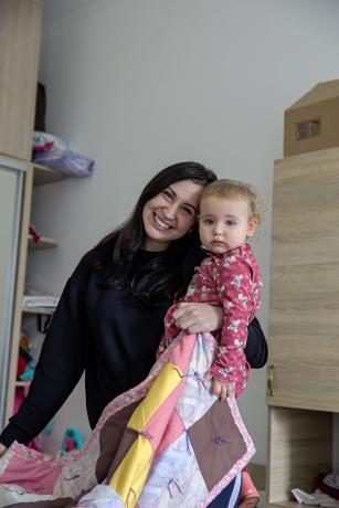 A woman holding a child and MCC comforter