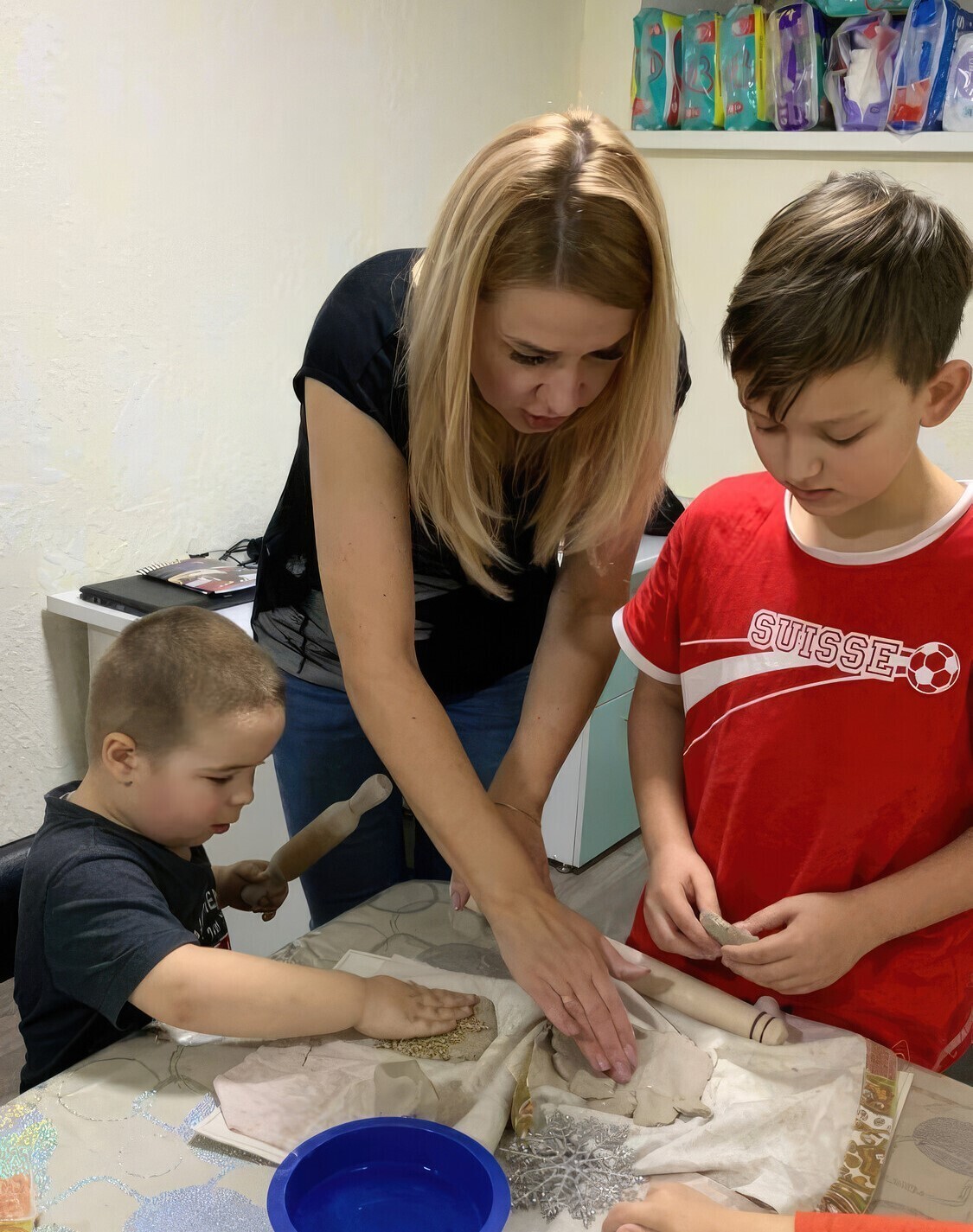 instructor helping children with clay projects