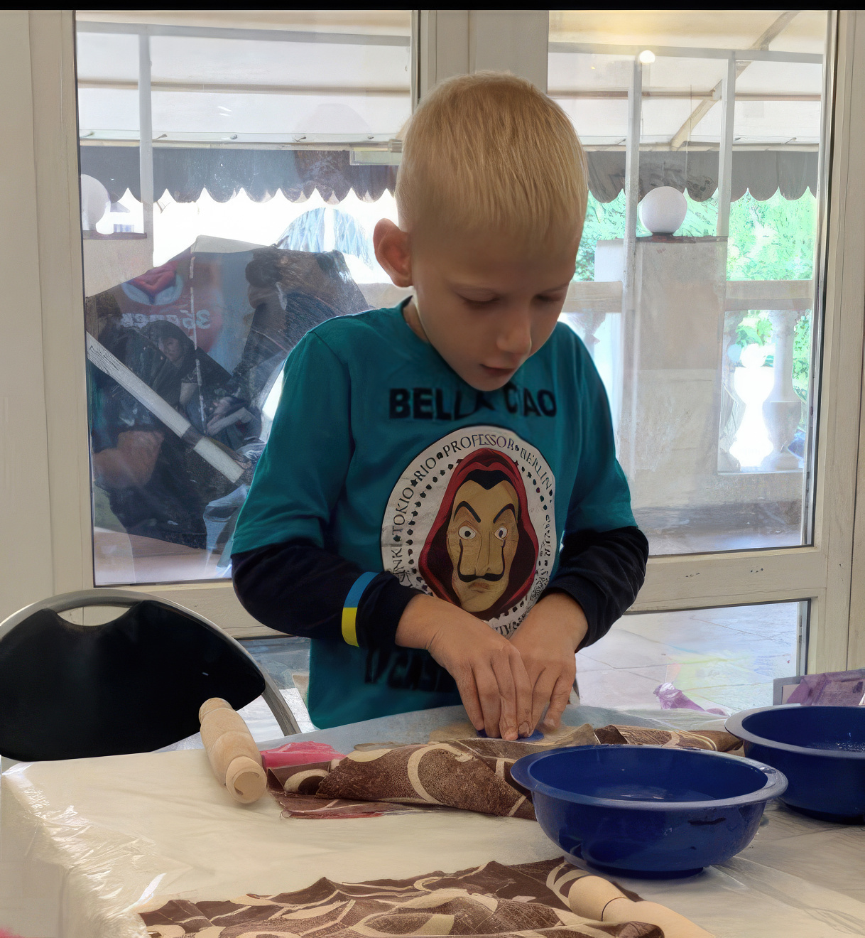 A young boy rolling clay