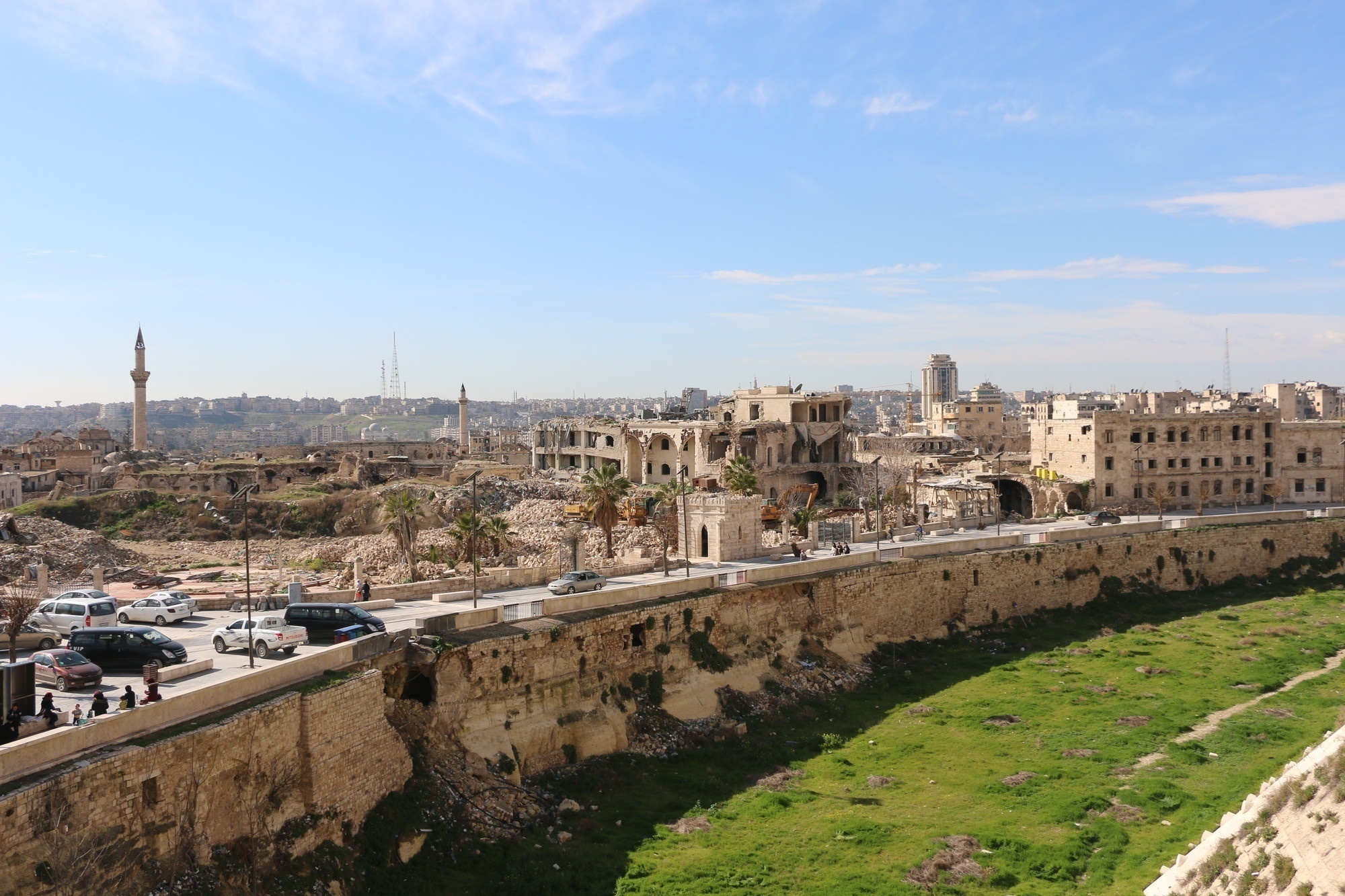 A medieval city wall surrounding a city that has been damaged from bombing