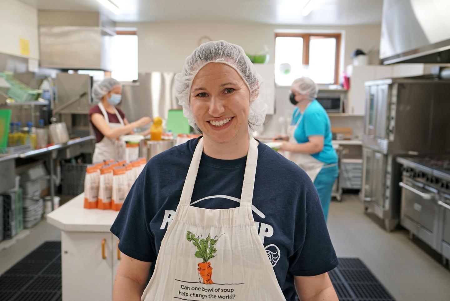 A woman smiling for a photo in a kitchen