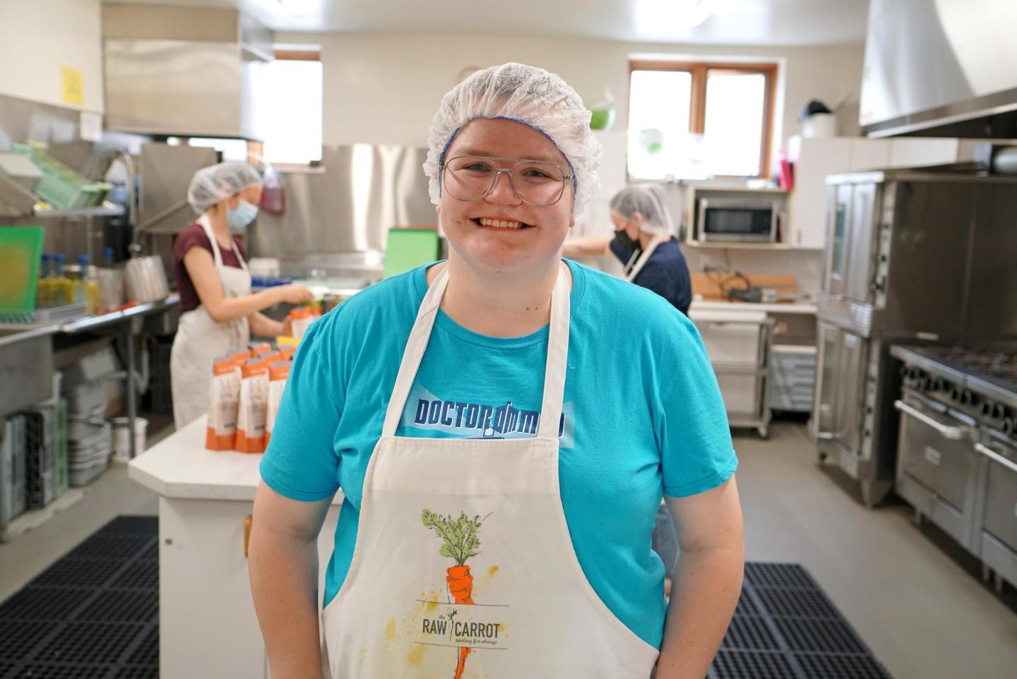 A woman smiling for a photo in a kitchen