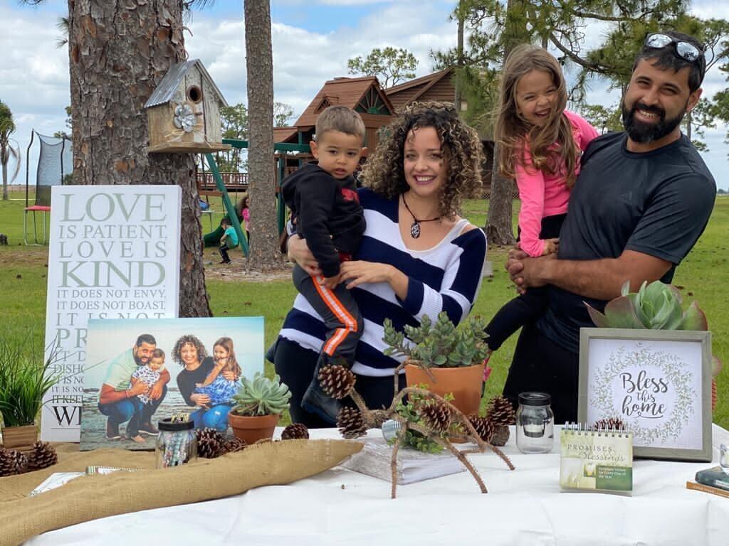 A family of four stands behing a decorated table outside