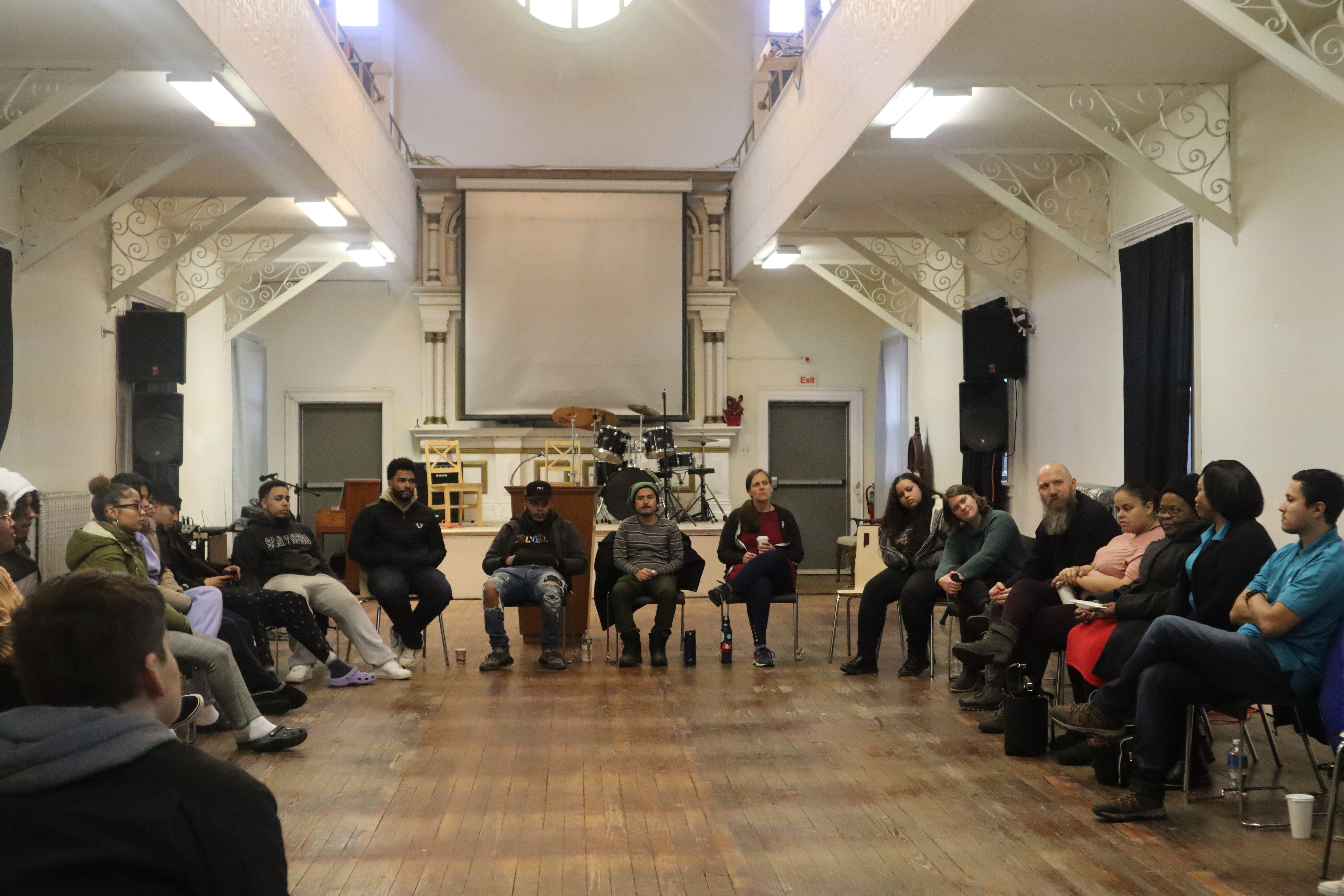 A group of people listening to panel speakers. 