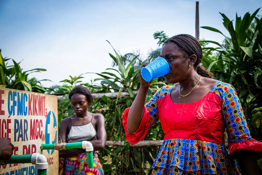 A woman drinking from a cup of water