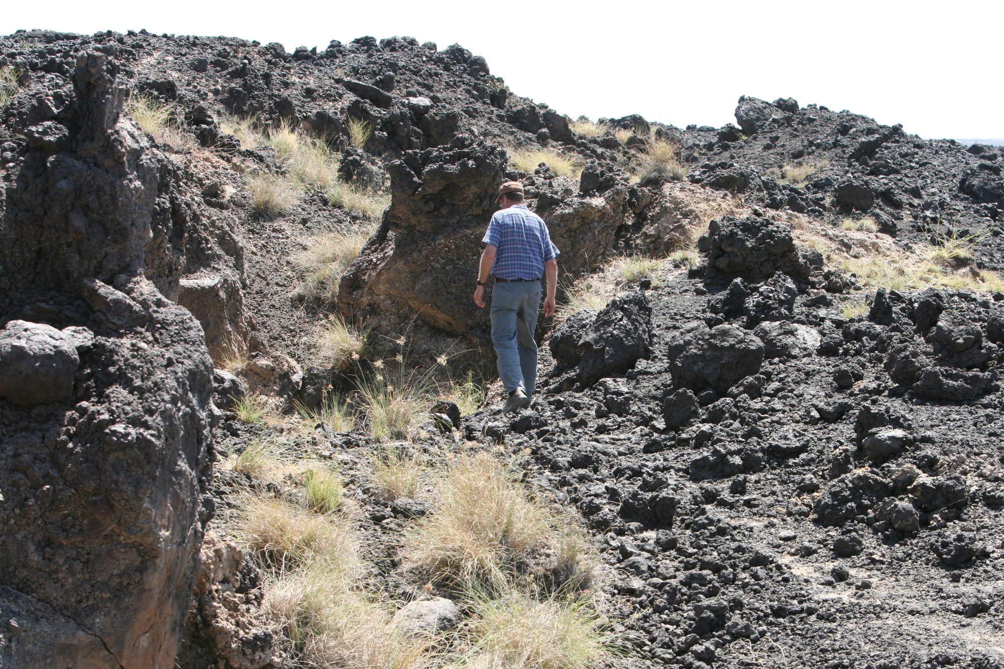 A man stands on a rocky hill