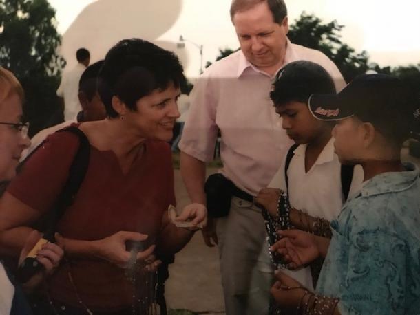 A group of tourists buy jewelry from kids