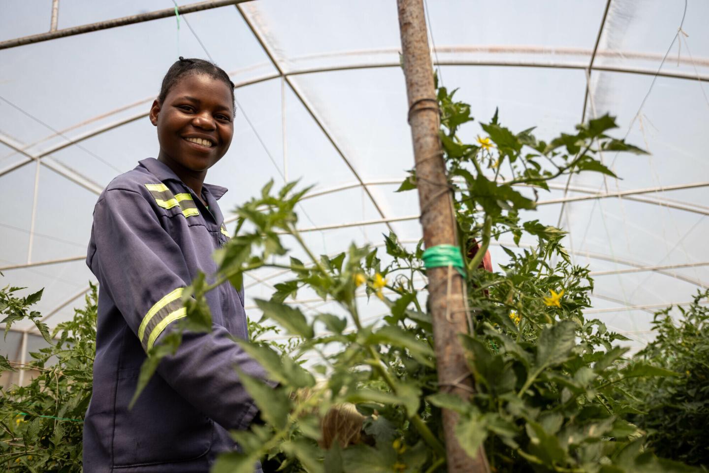 A girl stands in a greenhouse