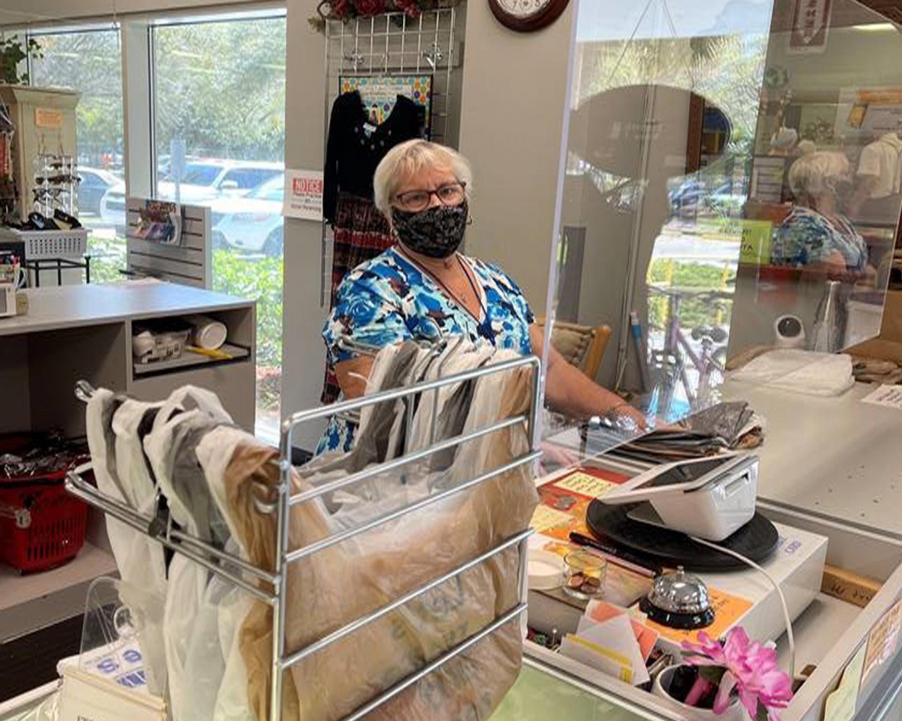 A woman operating a cash register in a thrift shop