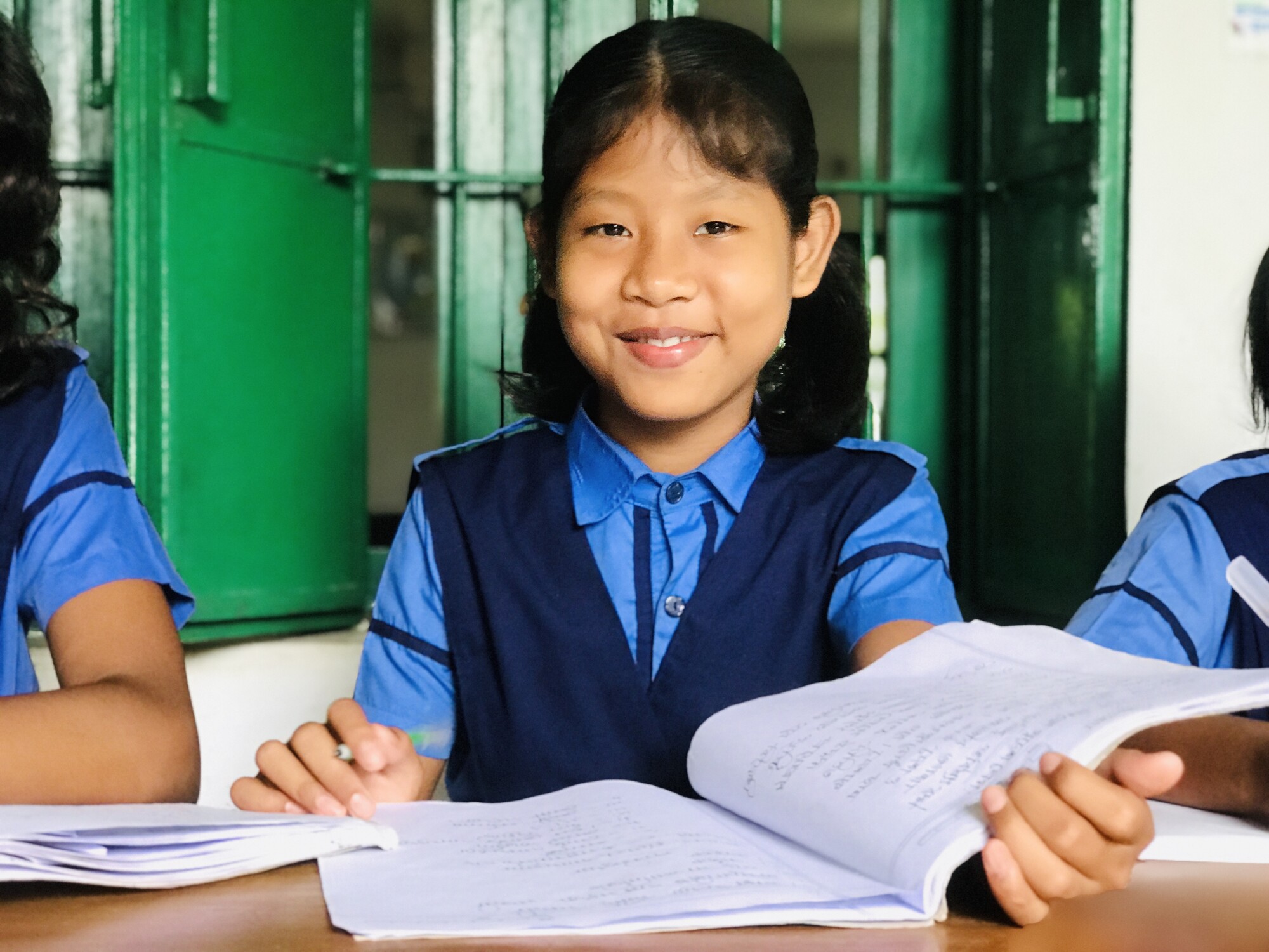 A young girl poses with her notebook