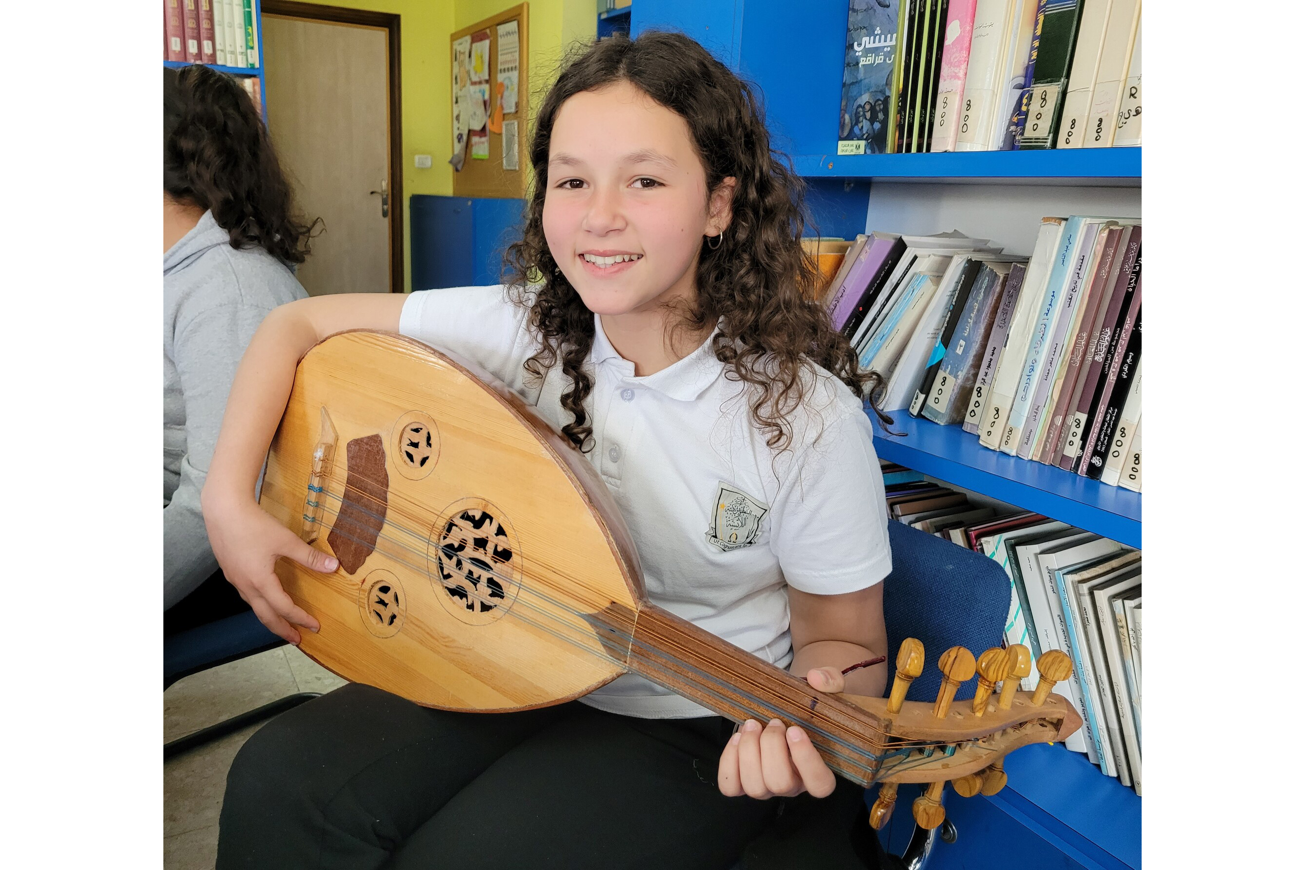 A young woman holds a stringed instrument