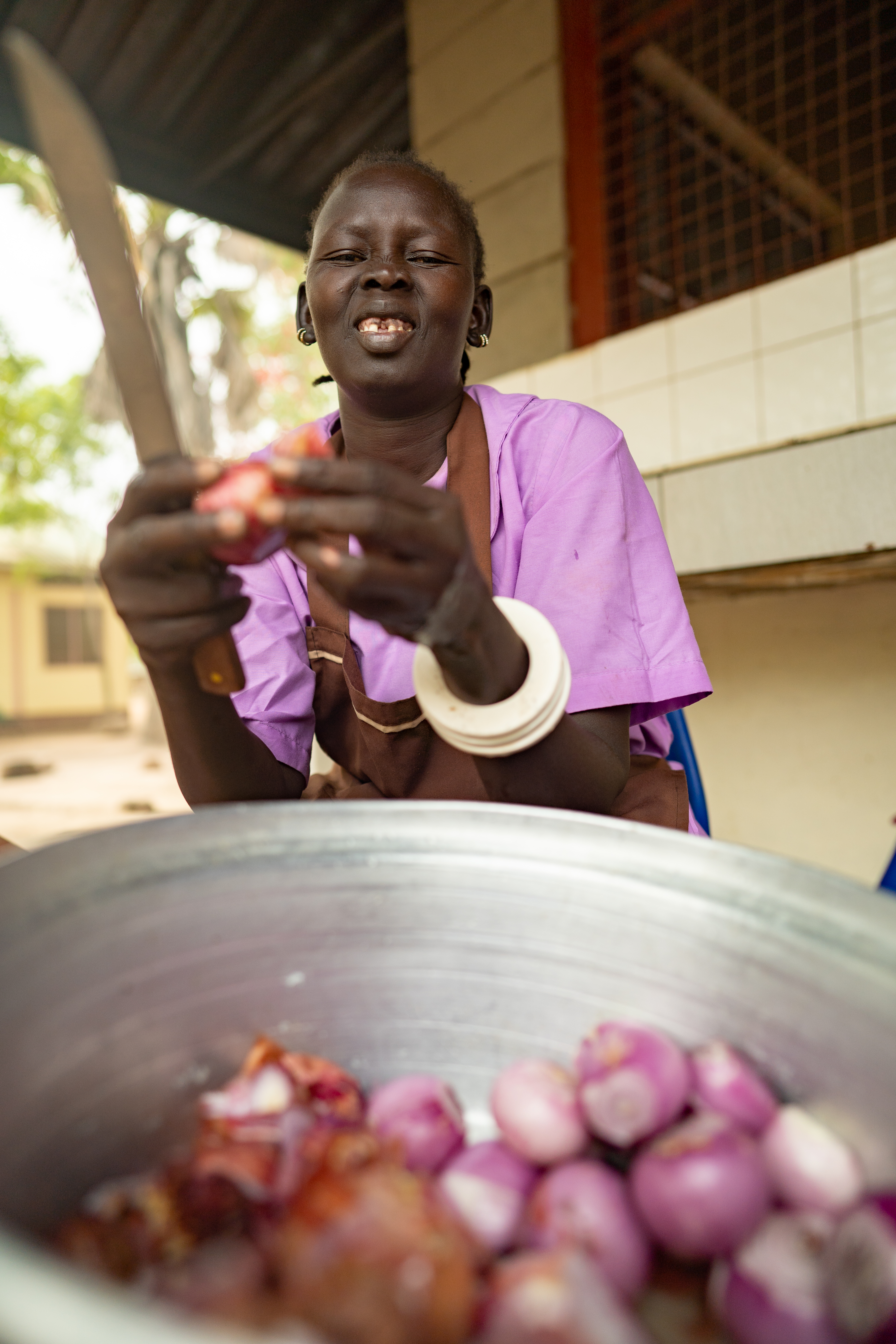 Elizabeth Yar Marial peels onions that were grown in the garden of Loreto Rumbek School. 