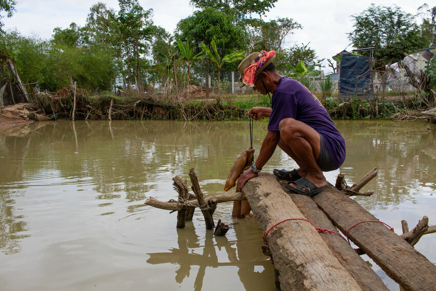 A man fishing by a river