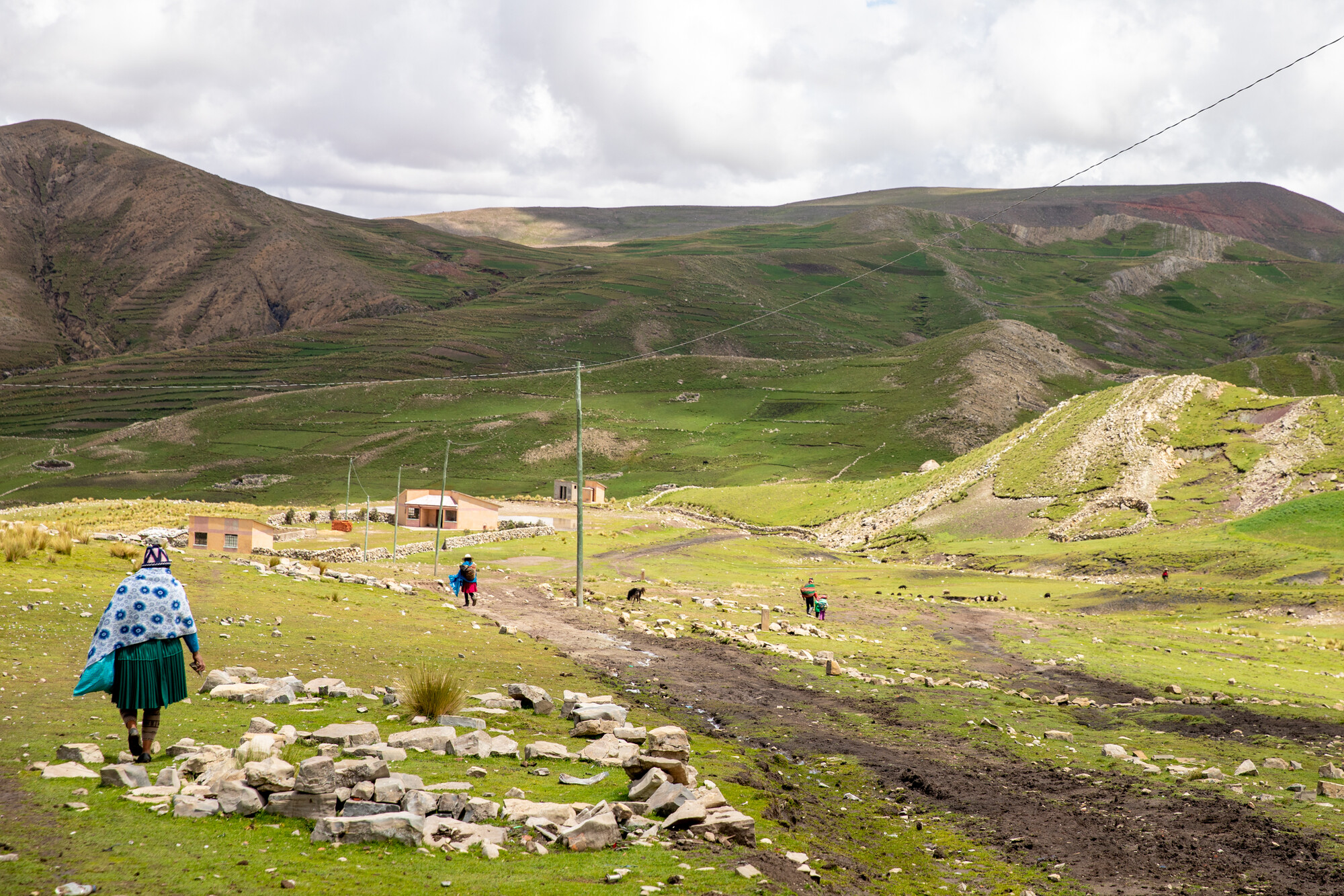 A woman walking towards a large hill in Bolivia