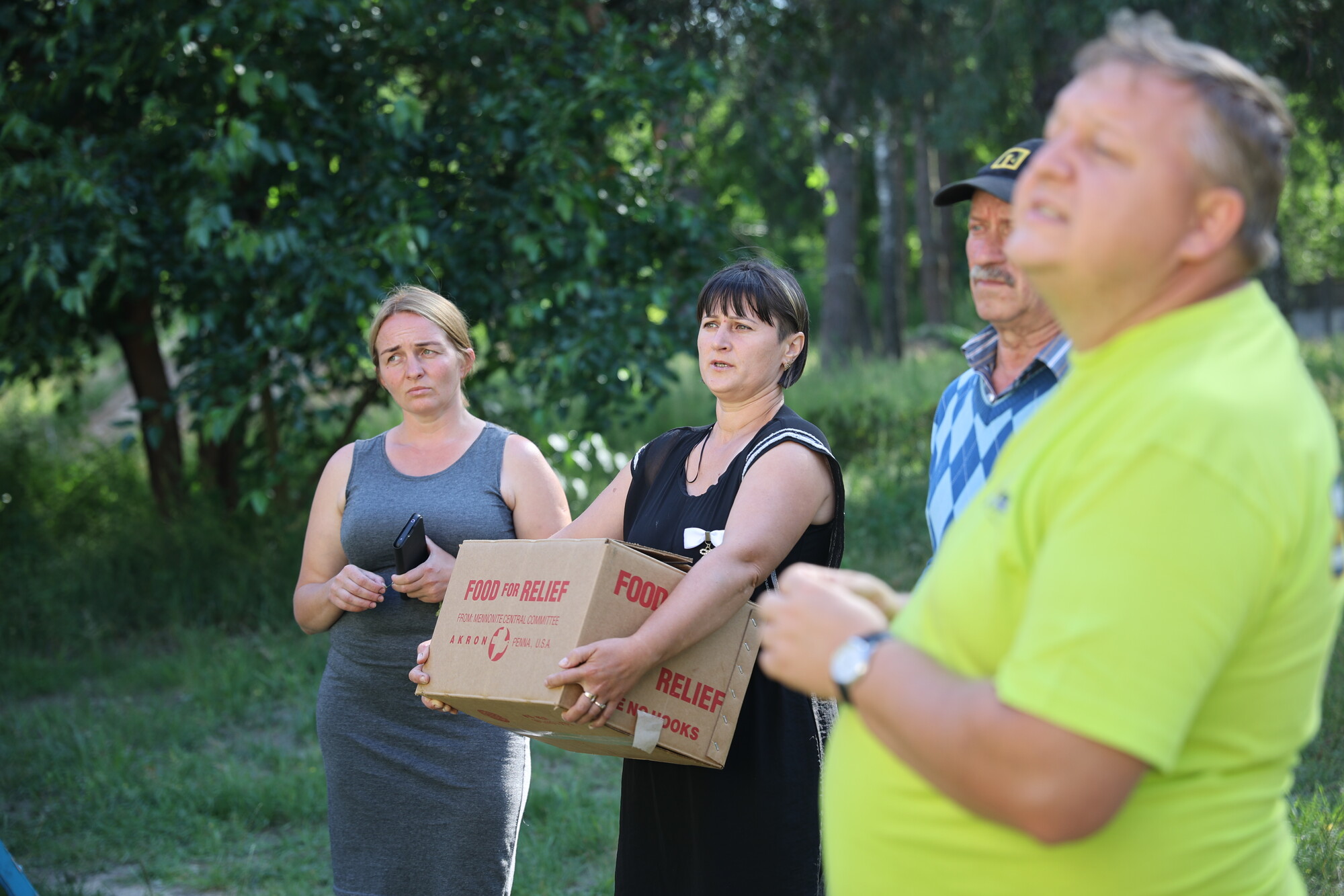 A group of people receiving cans of meat in Ukraine