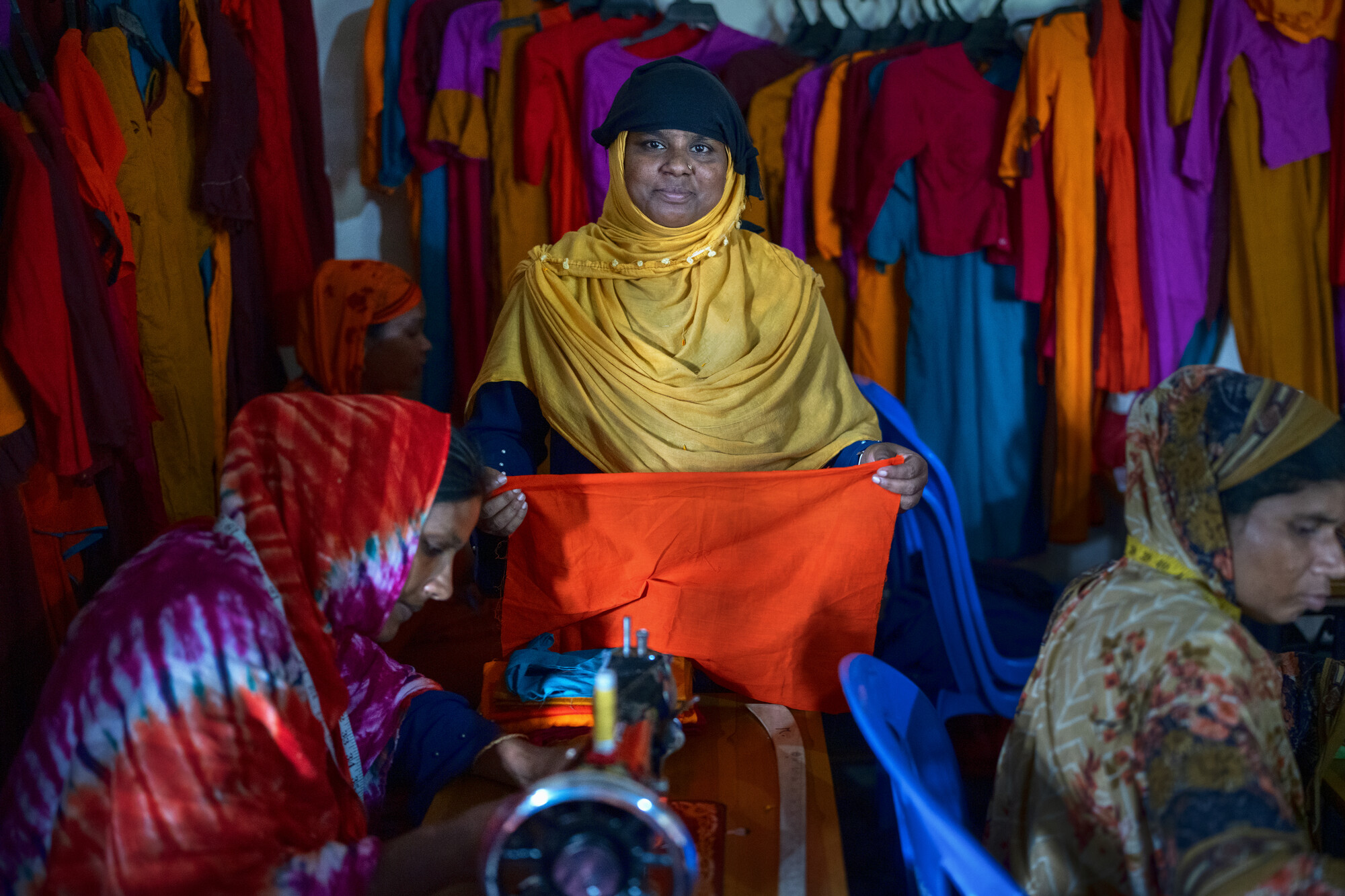 teacher standing between two sewing students