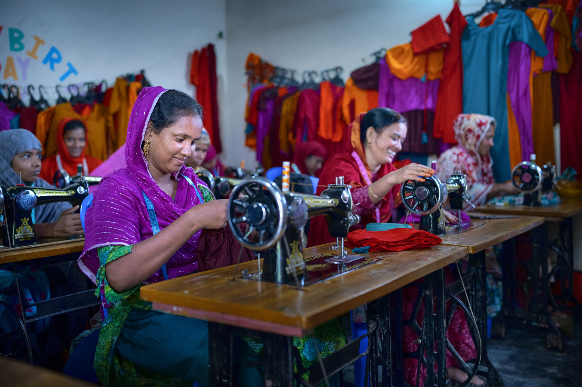 Several women working behind treadle sewing machines