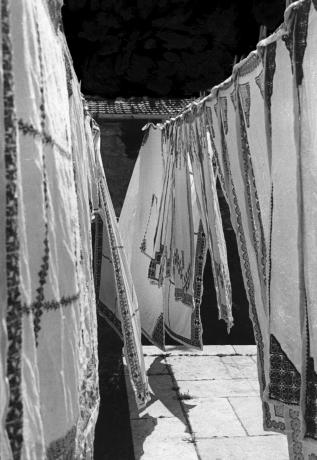 A black and white photo of Palestinian tapestries hanging