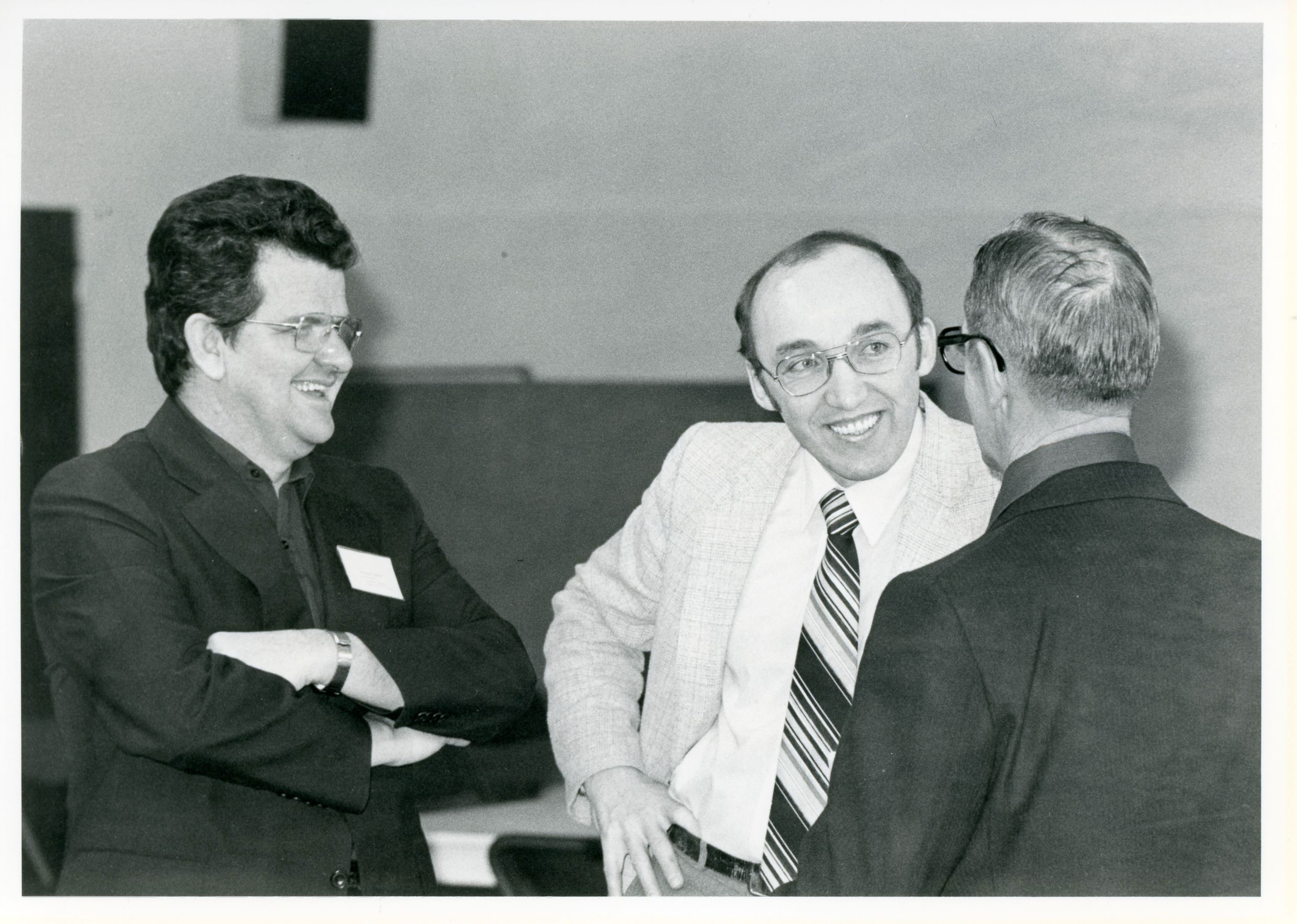 Three men are engaged in a conversation