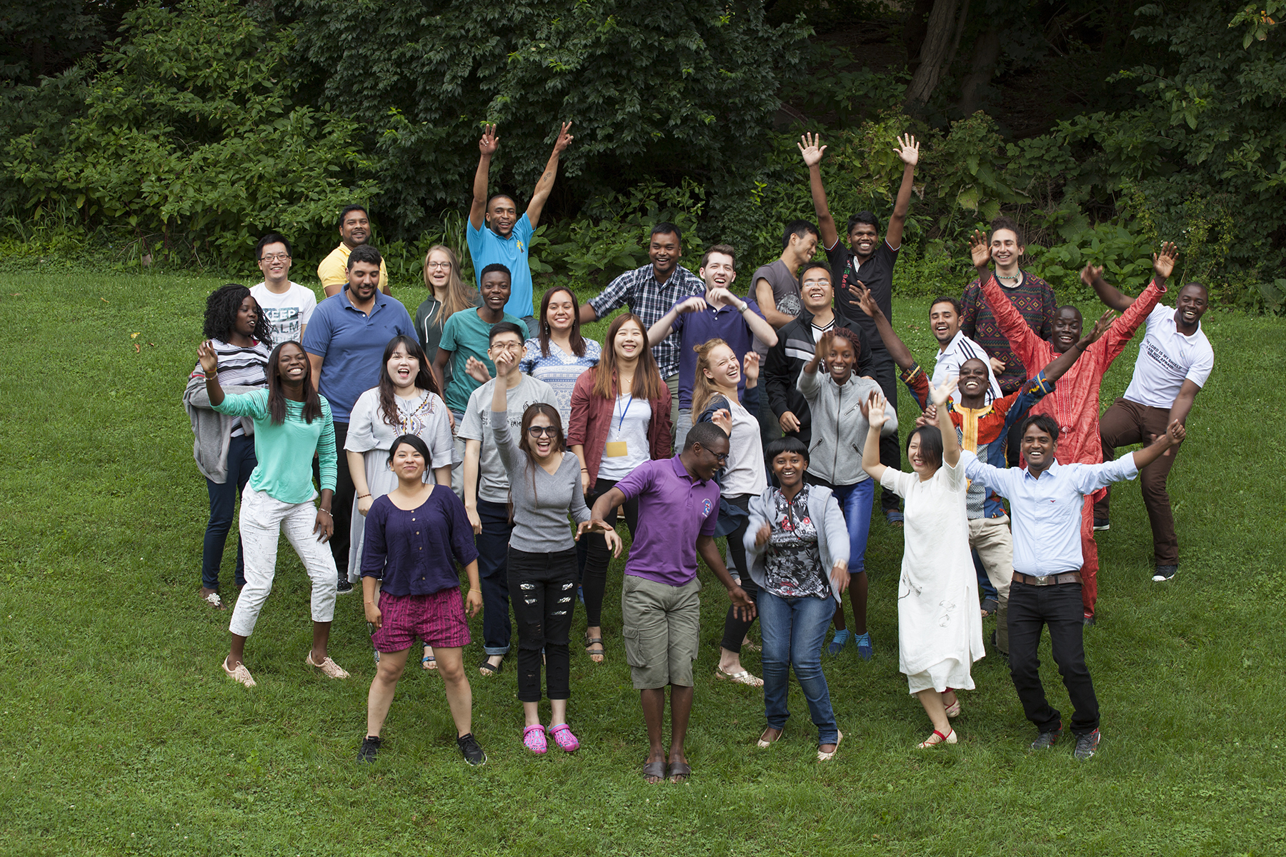 IVEP participants stand together in a grassy field.