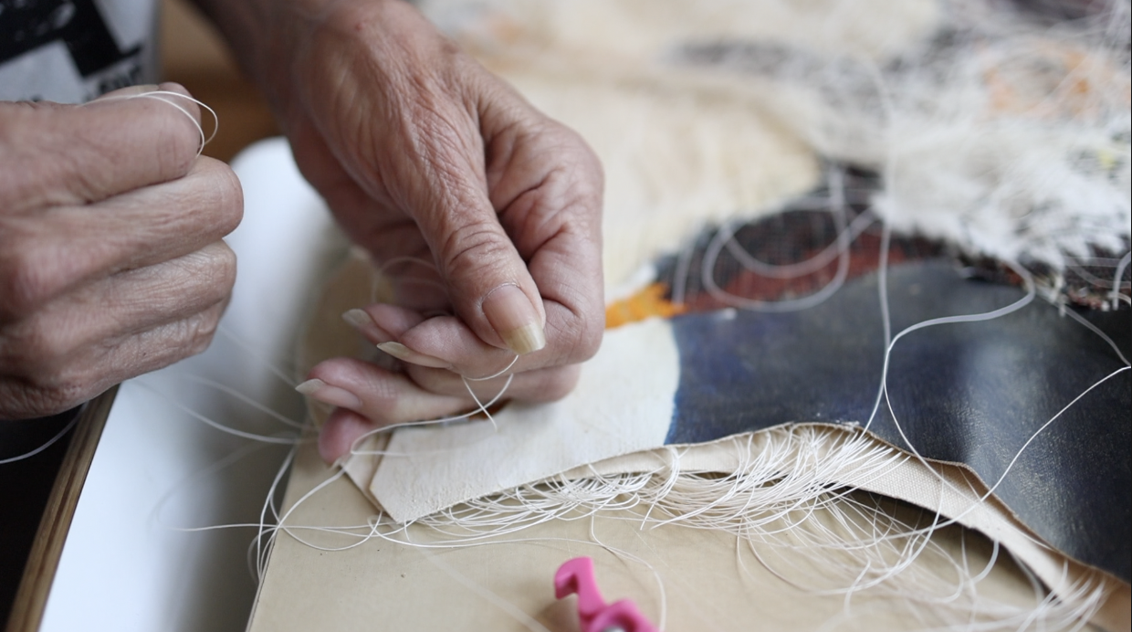 Artist Val Vint's mature hands manipulate natural materials.