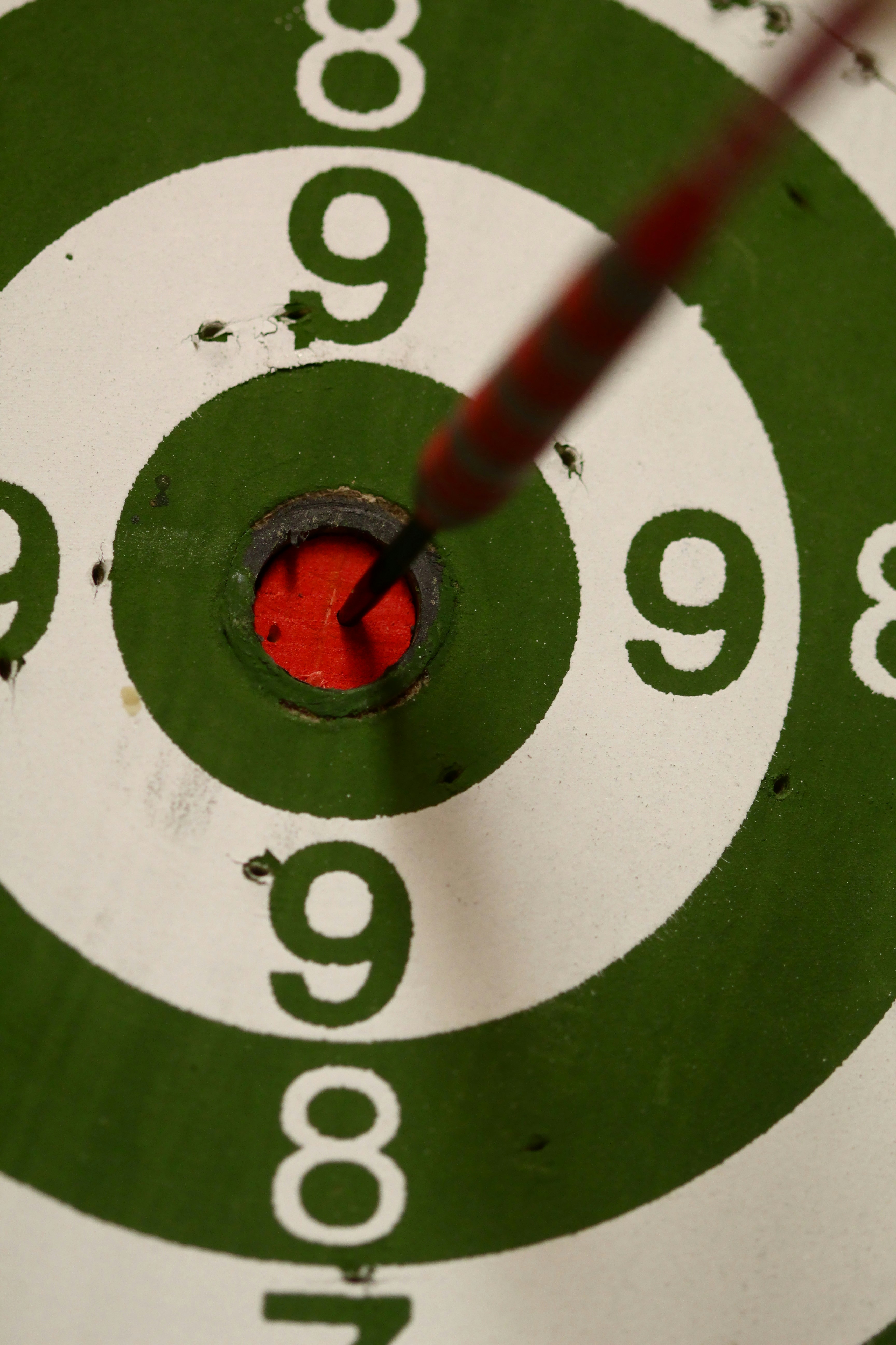 A dart is in the centre of a dartboard.