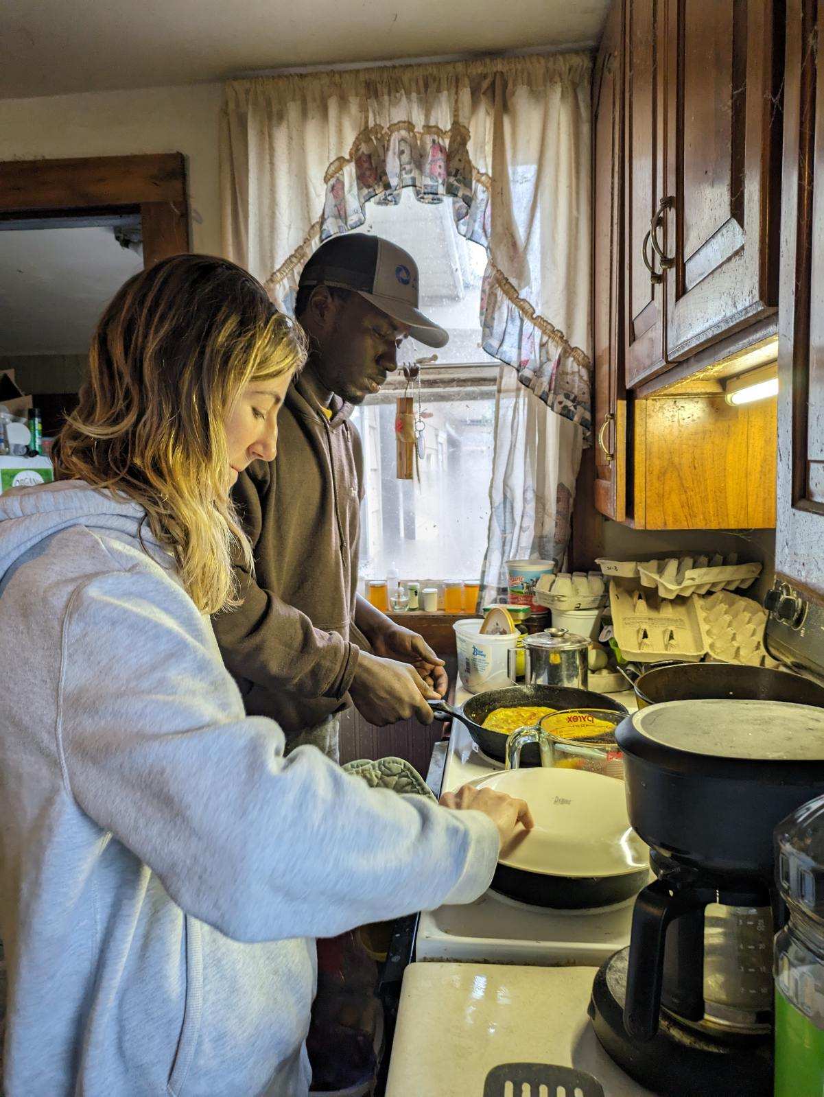 IVEPer and another person stand at a stove cooking together.