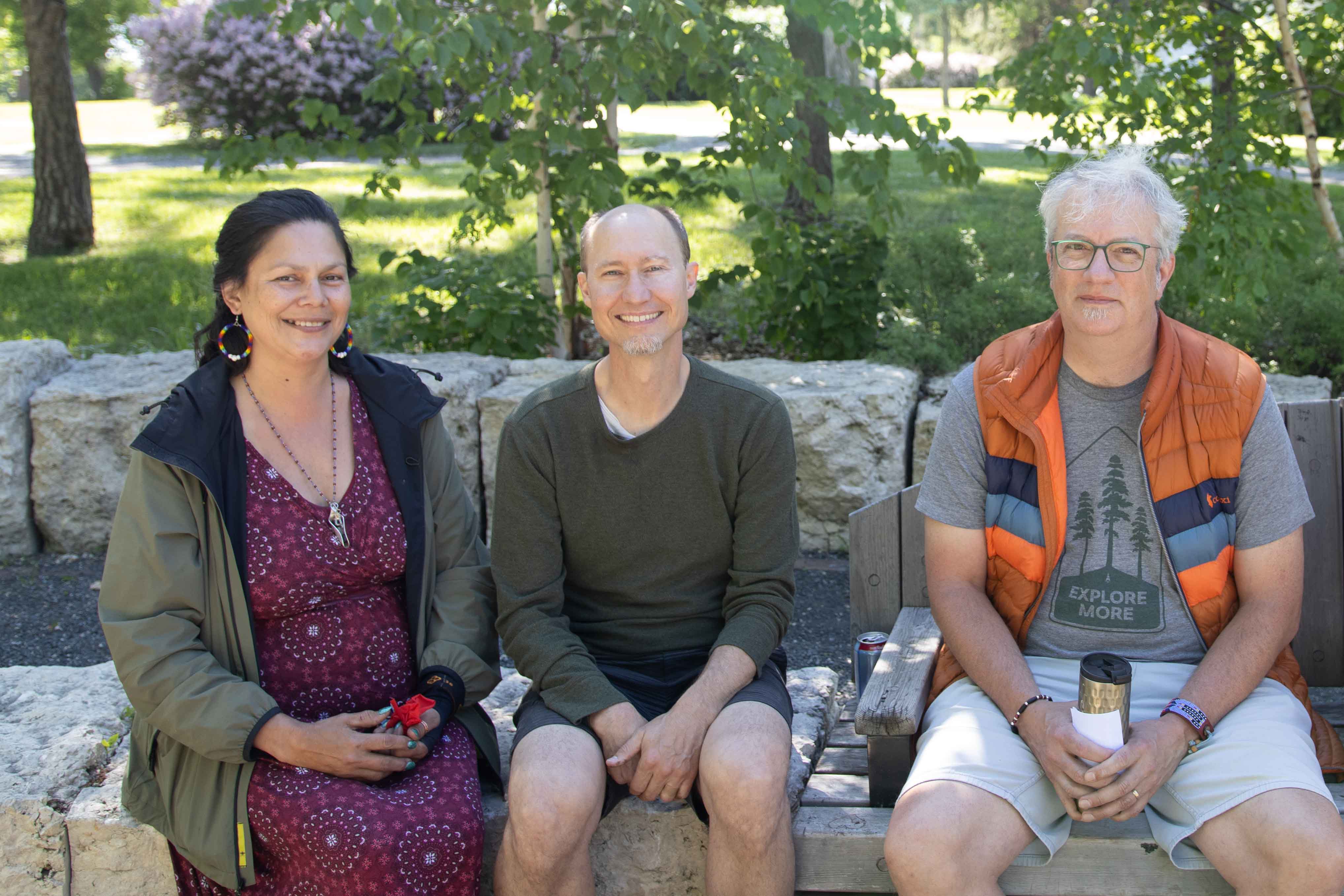 Ko’ona Saber, Kerry Saner-Harvey and Jonathan Neufeld sitting together on a bench