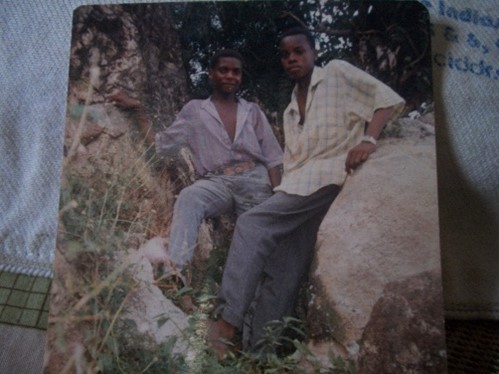 Aged photograph of two people sitting outdoors.