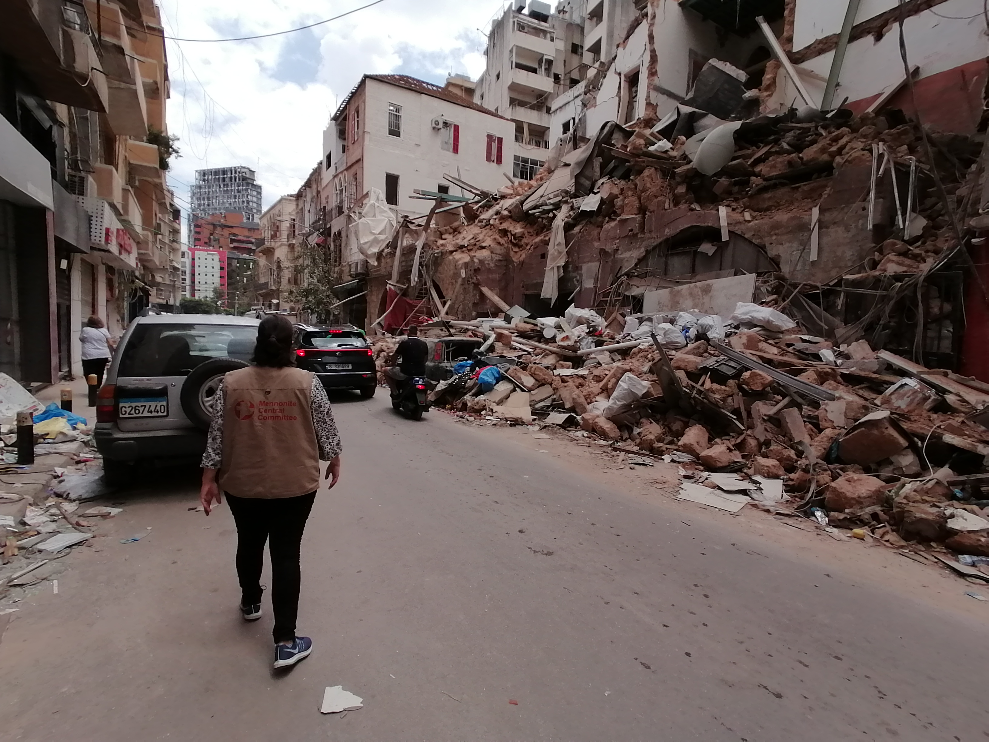 An MCC representative walks near a building that had been destroyed by unsafely stored chemicals.