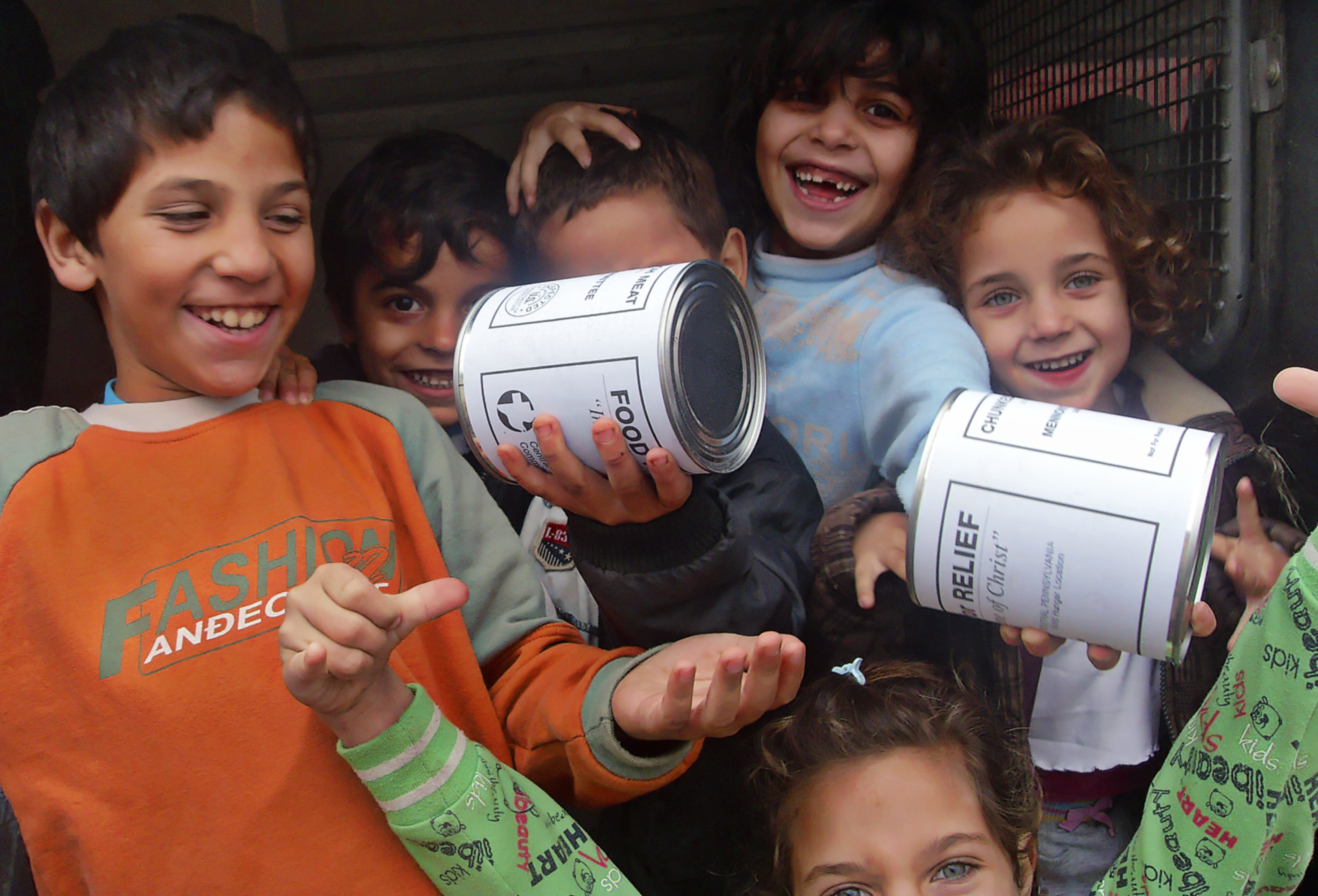 Kids holding cans of meat