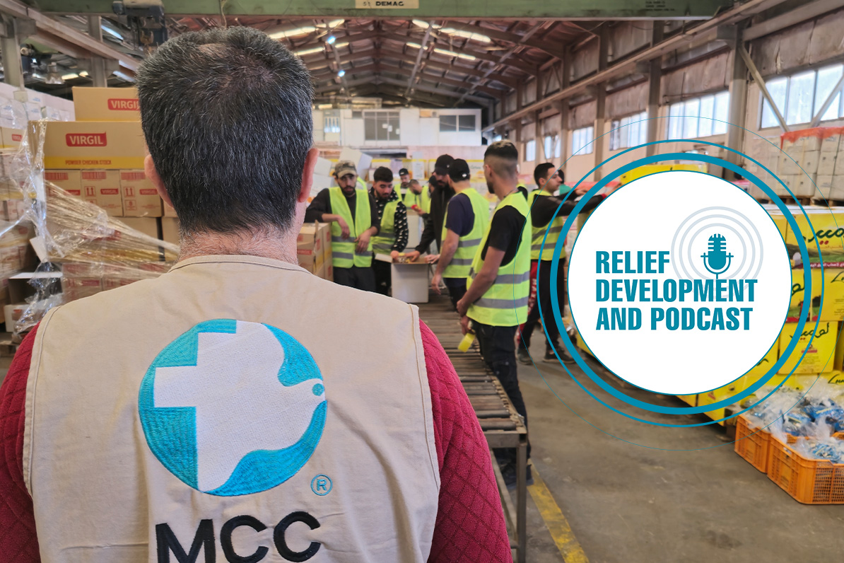 An MCC staff member observes workers packing emergency food packages in Amman, Jordan.