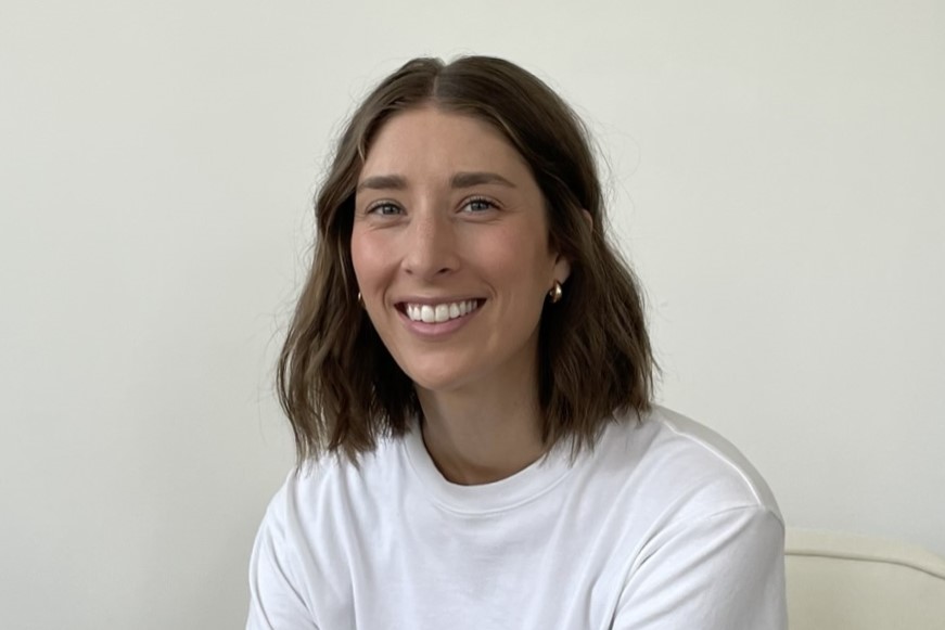 Jodi Enns, smiling in front of a beige backdrop.