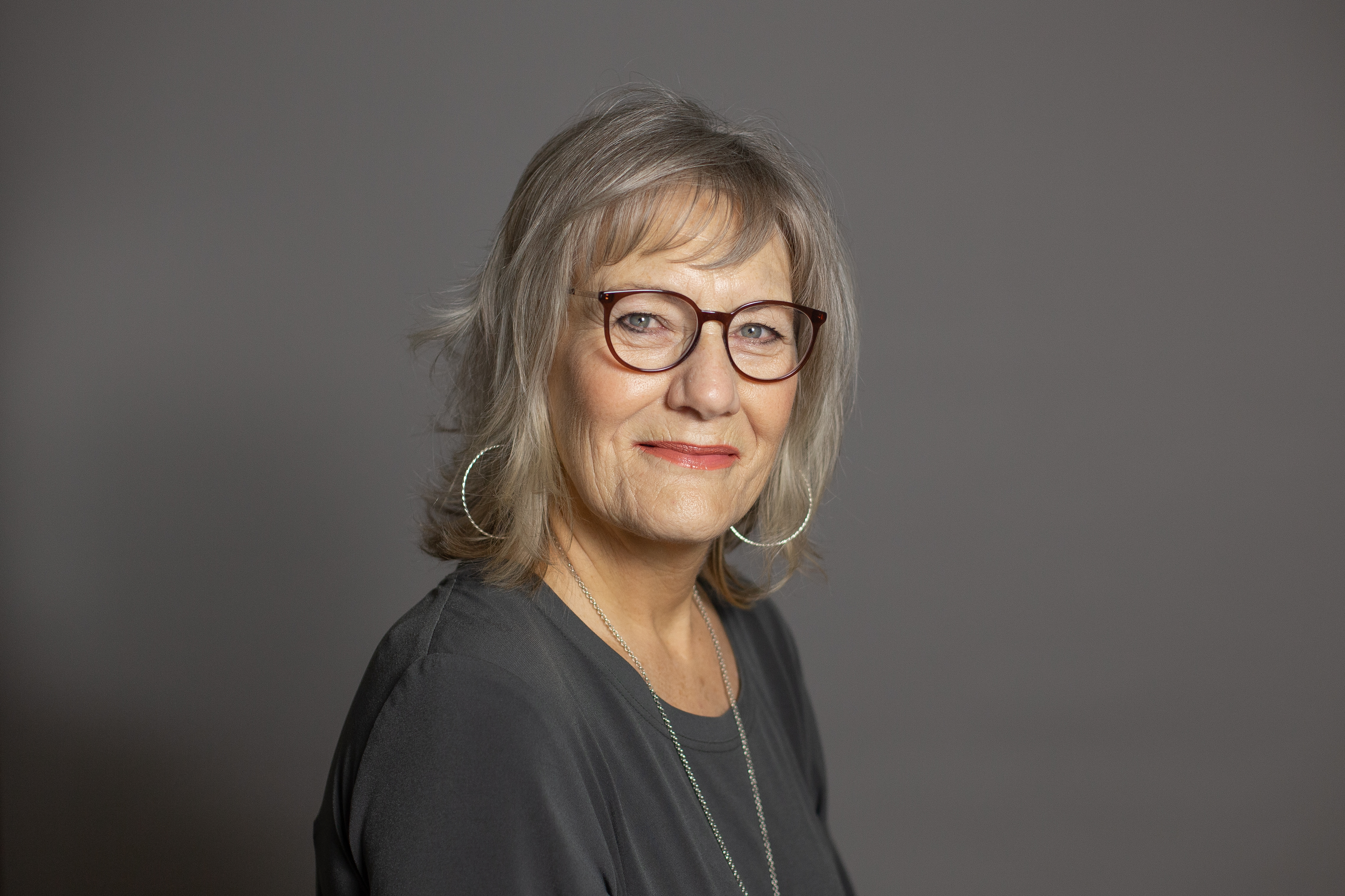 Lydia Fawcett pictured, smiling in front of a grey backdrop.