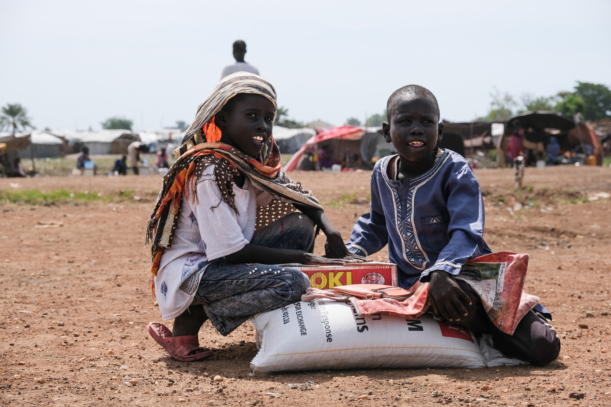 Two young kids with a bundle of food.