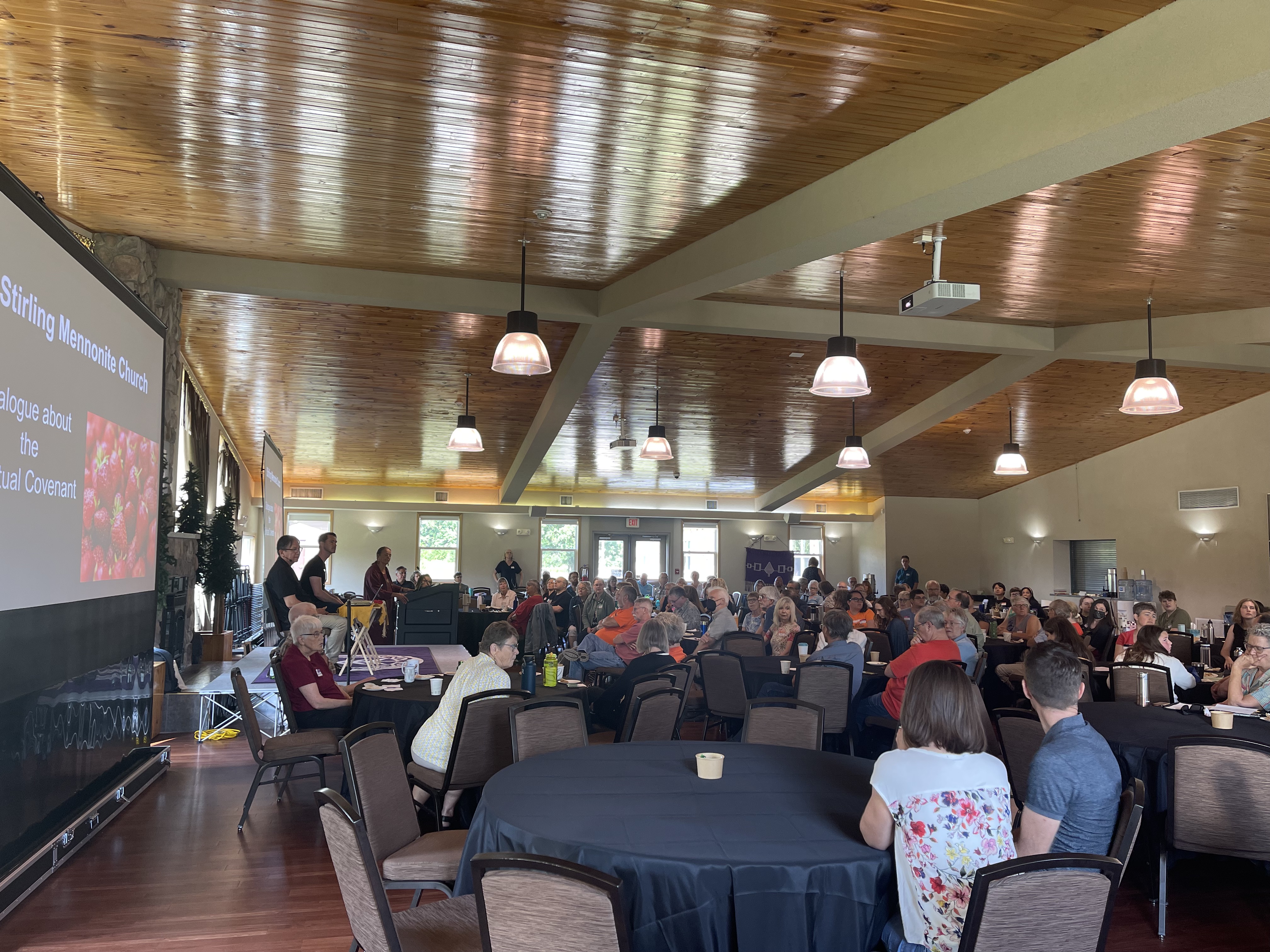 a room full of people sitting around round tables