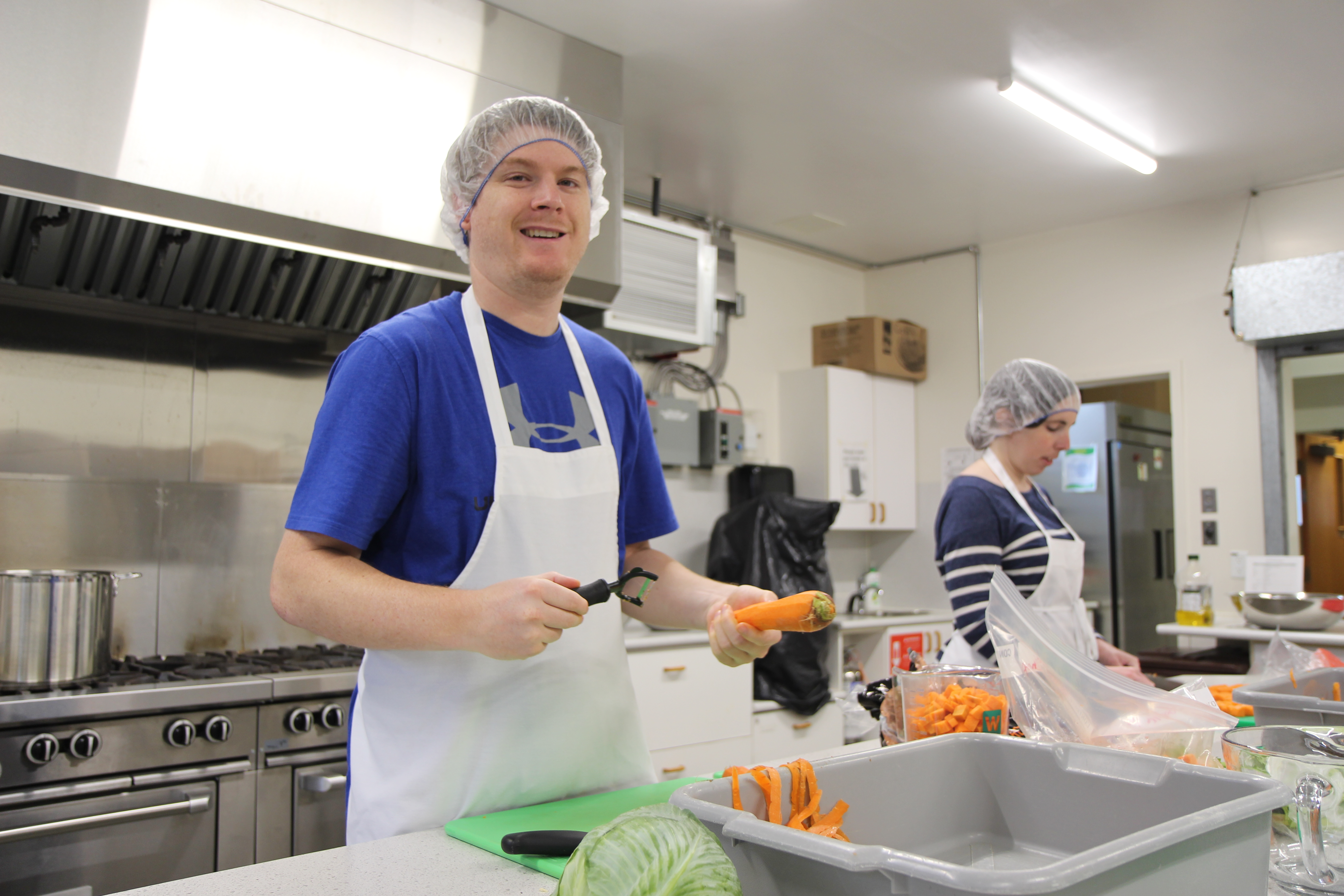 man cuts vegetables to make soup