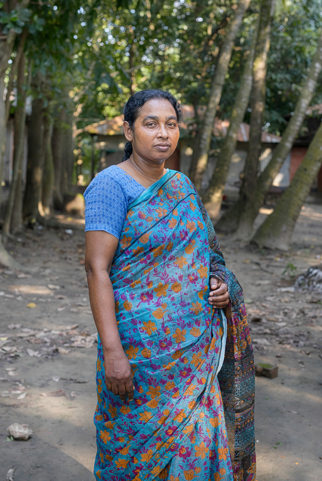 A person wearing a blue garment stands facing the camera.