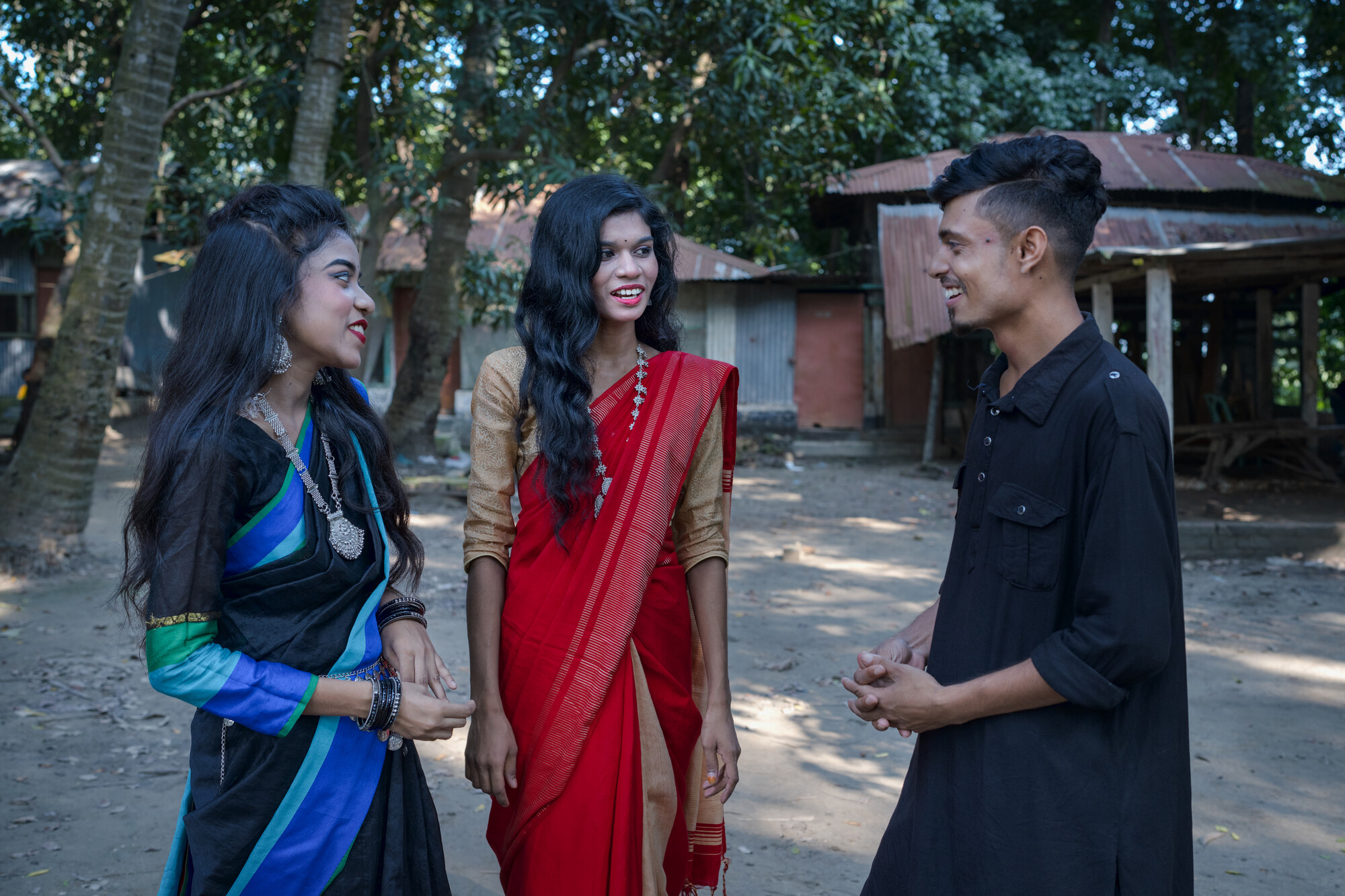 Two students face a third, who is talking.