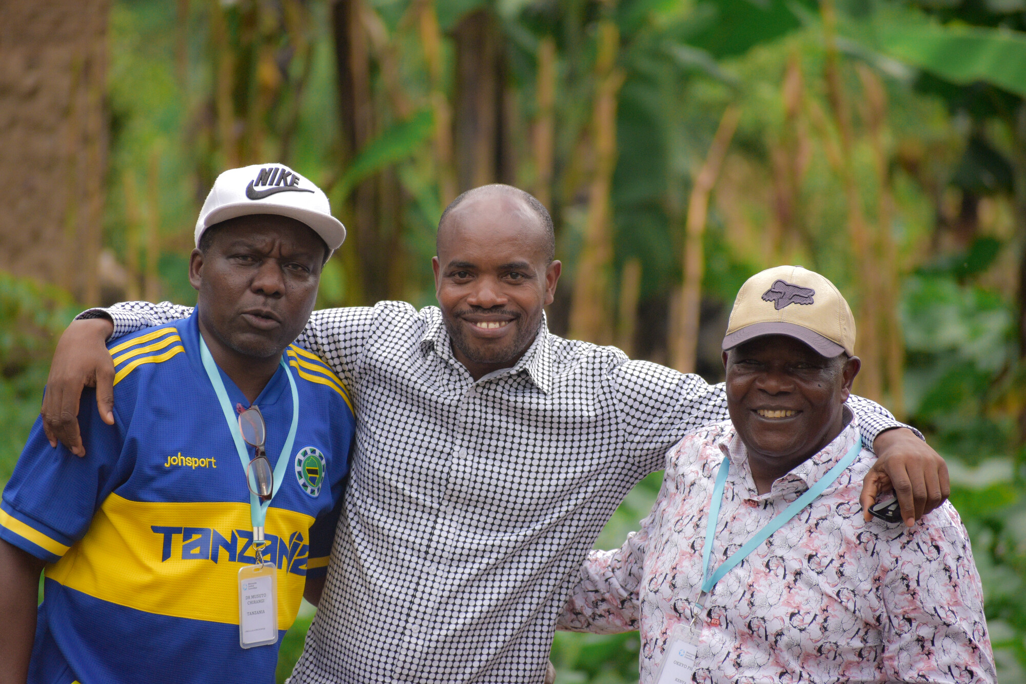 three men standing arm in arm