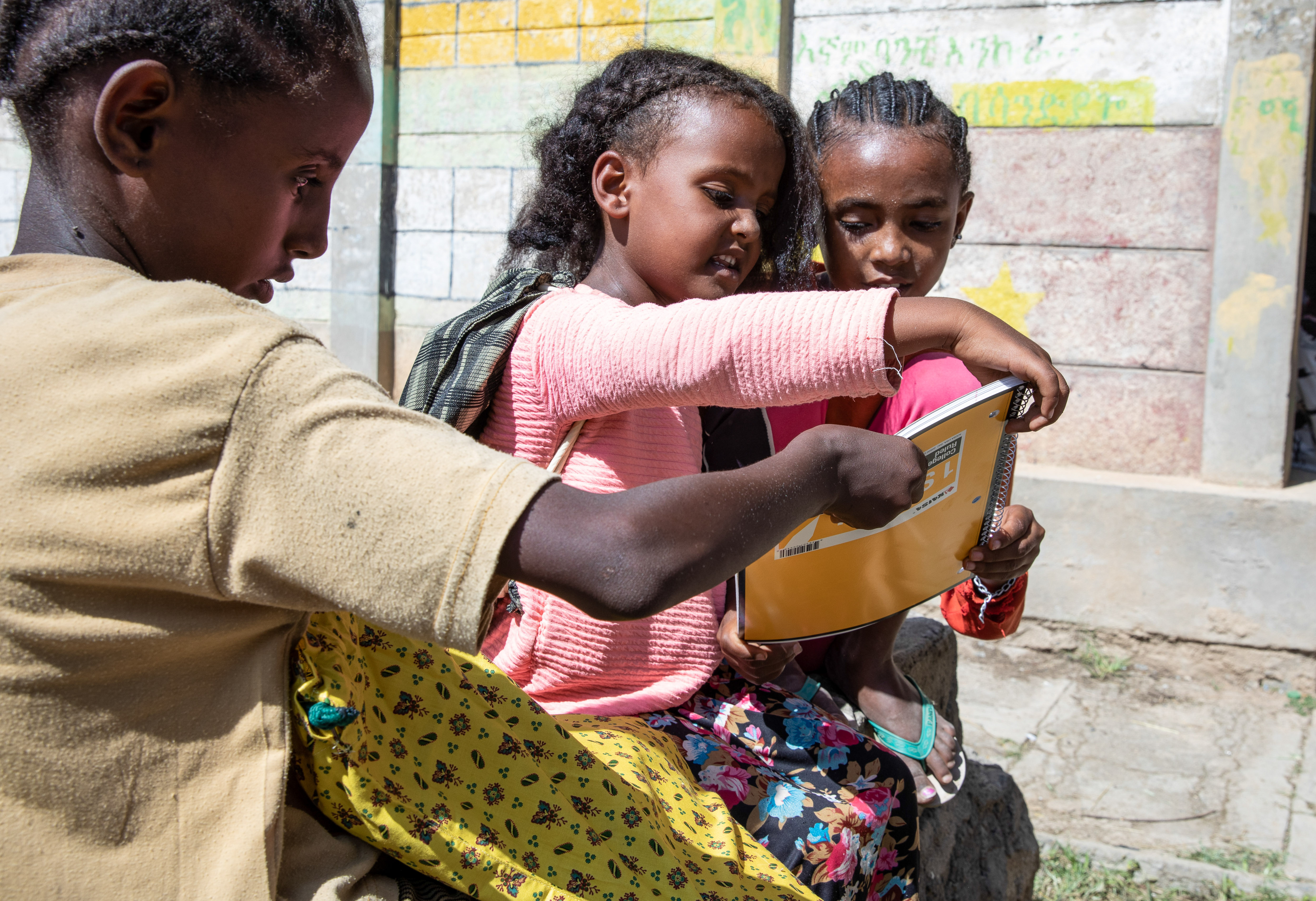 three students examining school kit supplies