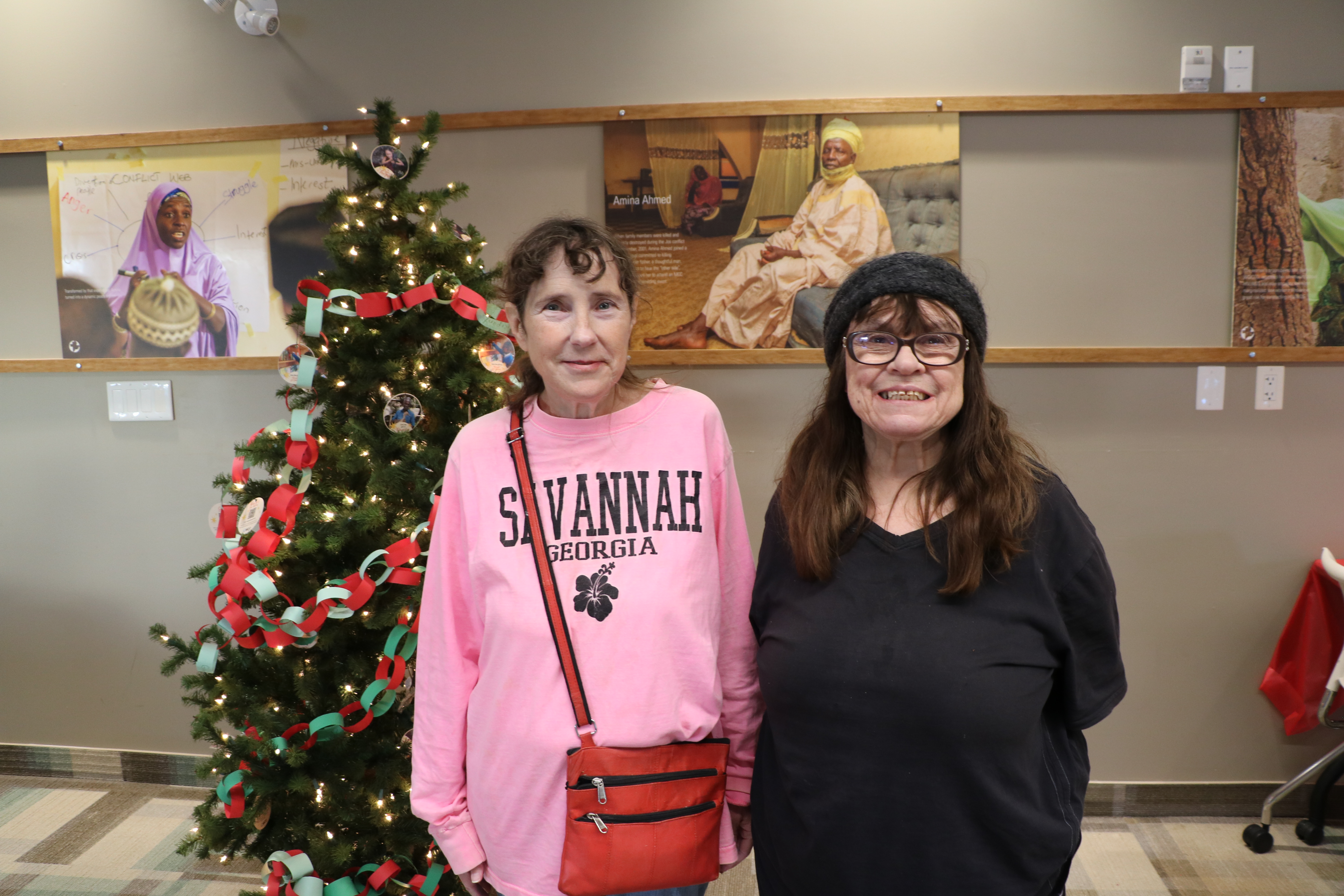 Two women standing in front of Christmas tree