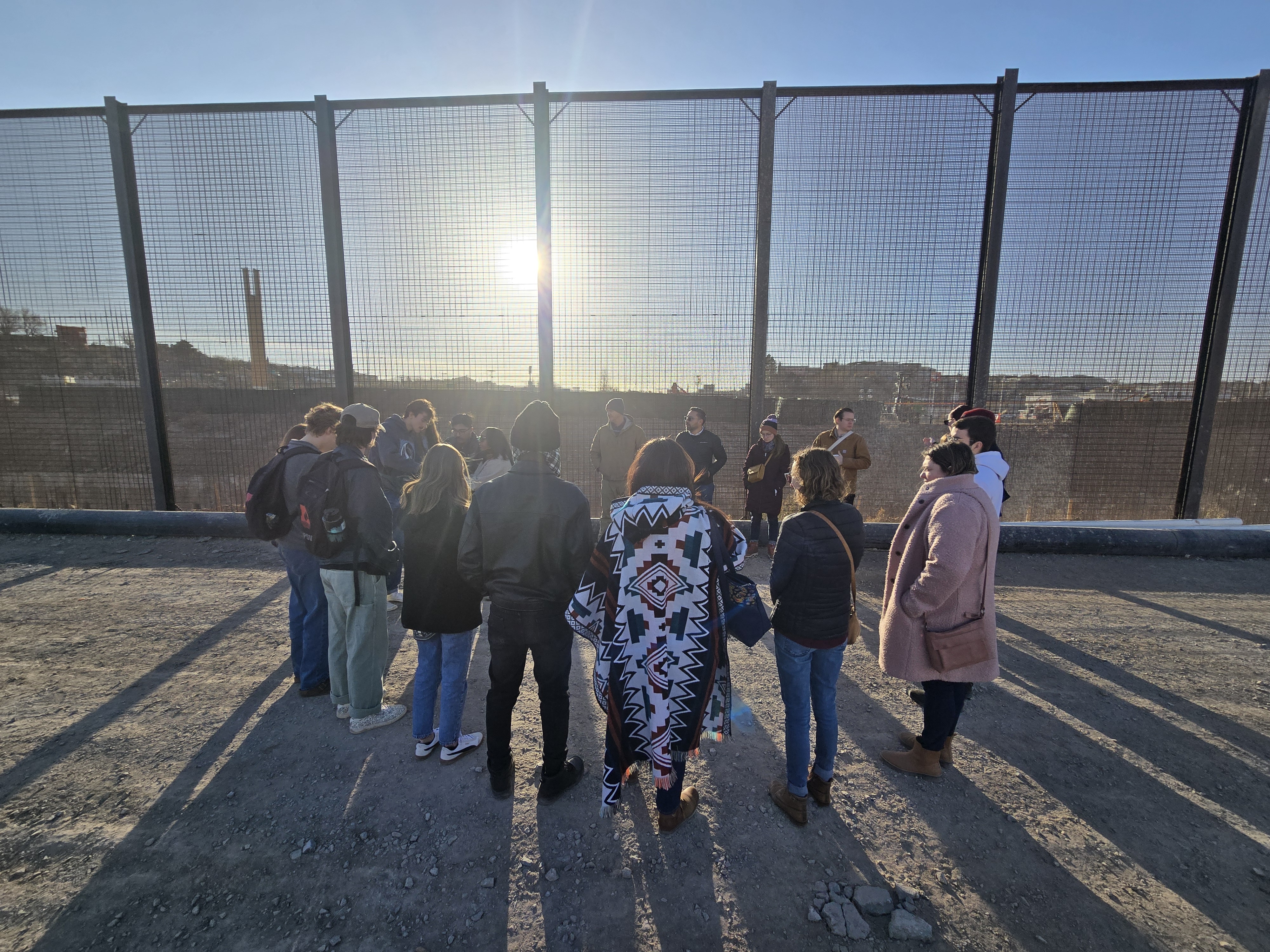 people circled around US - Mexico border wall