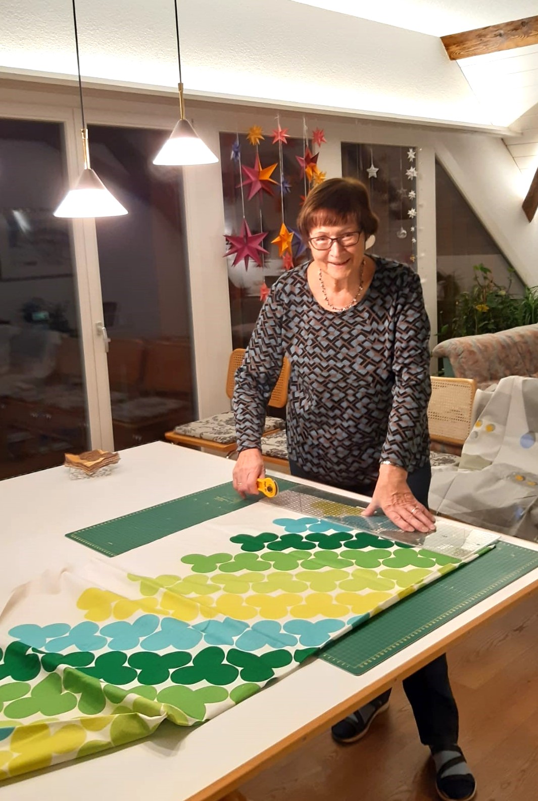 woman standing beside table covered with a comforter top